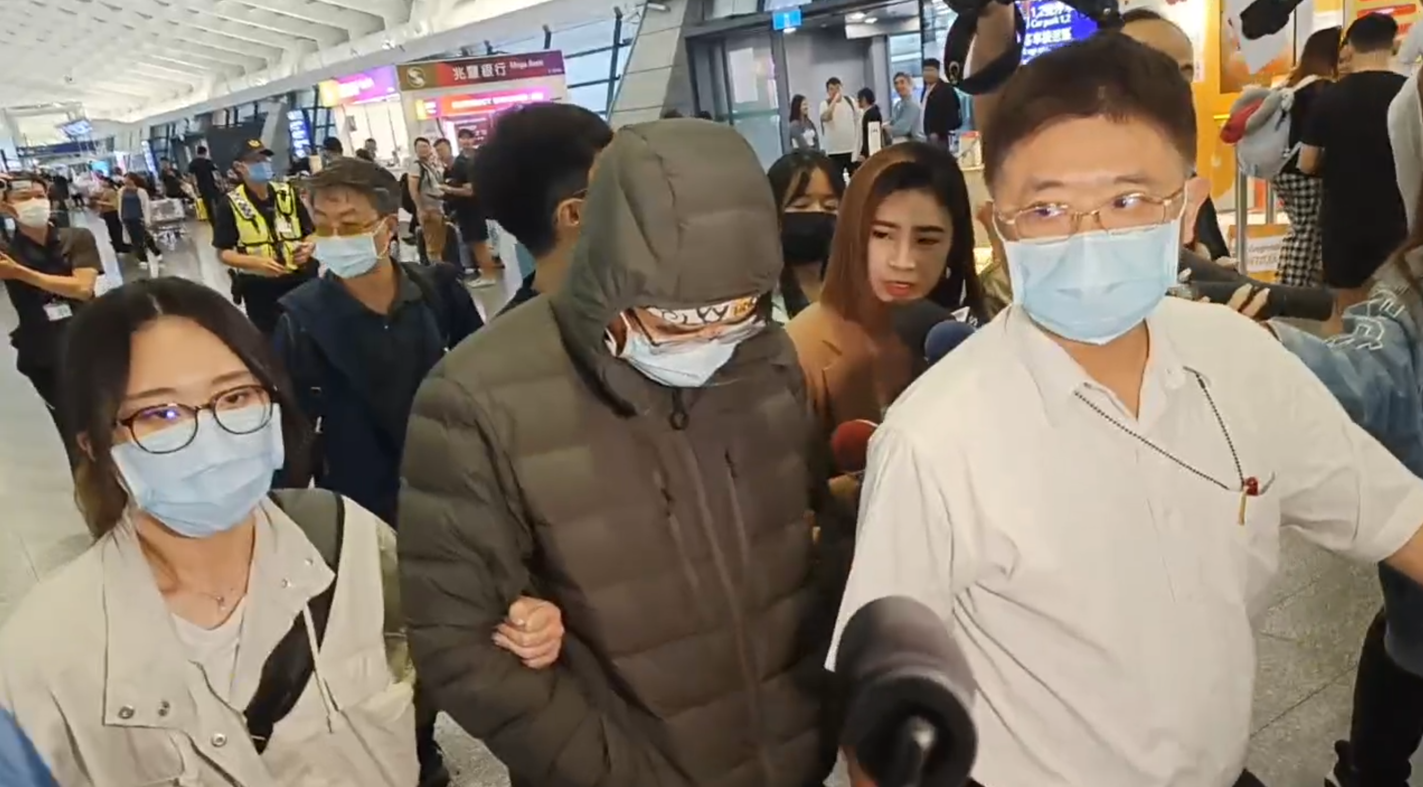 林裕紘（中）搭機返台，隨即遭警方帶走。（翻攝畫面）