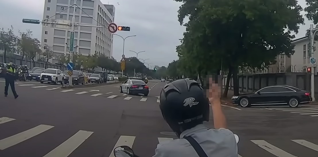 騎士不滿總統車隊途經路口交管時間過長，伸手比中指抗議。（翻攝自WoWtchout - 地圖型行車影像分享平台 YT頻道）