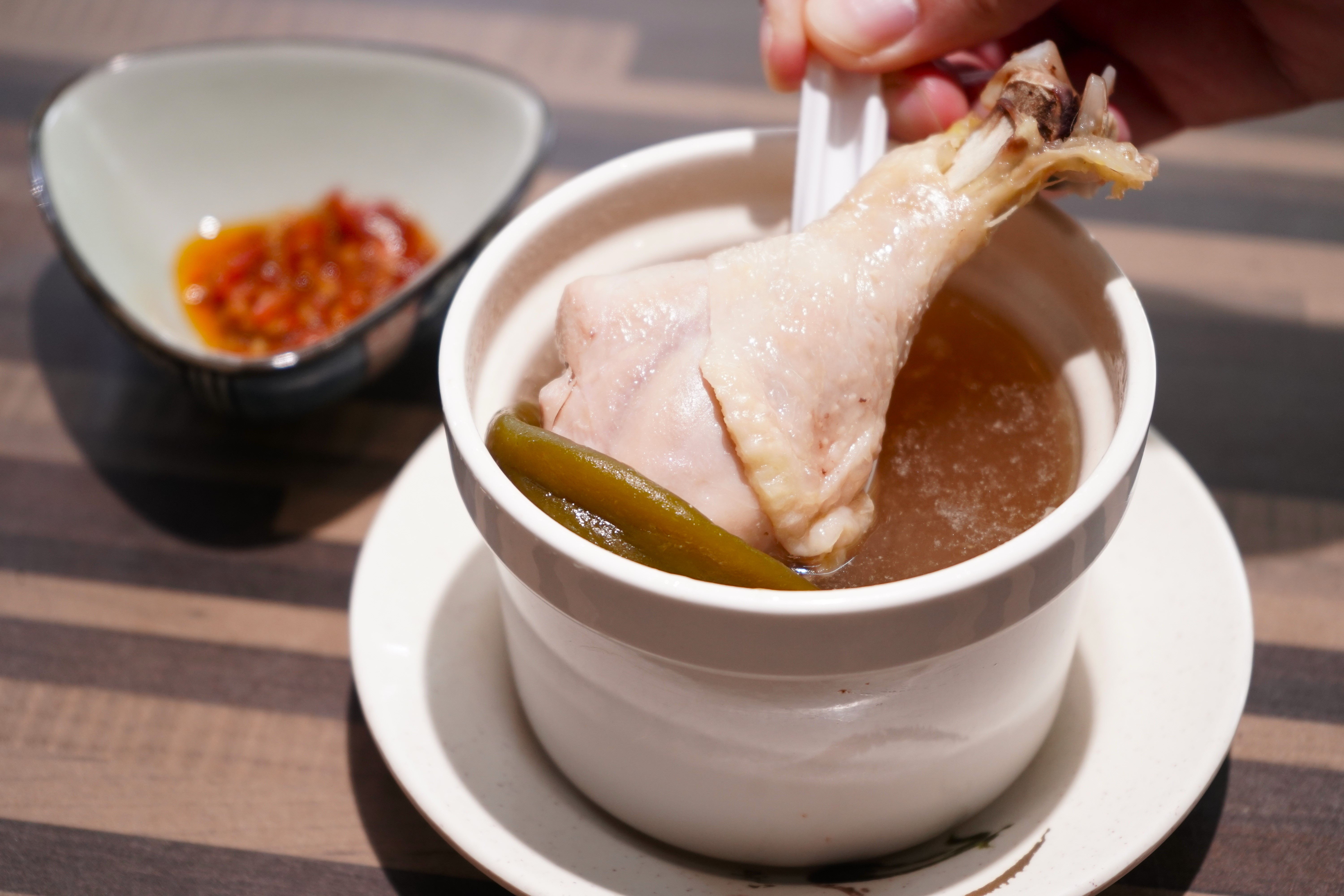 「辣妹湯」喝得到剝皮辣椒的辛辣和甘甜味，雞腿肉軟嫩不柴。（70元／碗）