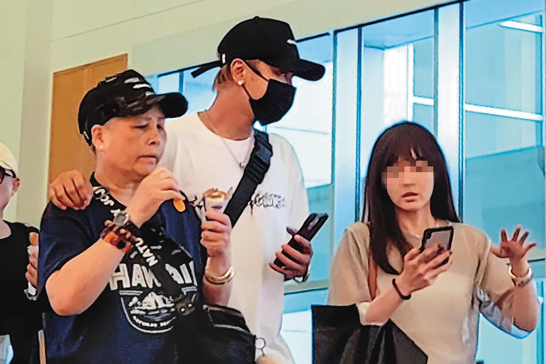 9/25 13：53 小豬（中）攬著邊吃冰淇淋邊走路的羅媽媽（左），出現在沖繩機場。右為與小豬討論工作行程的女助理。