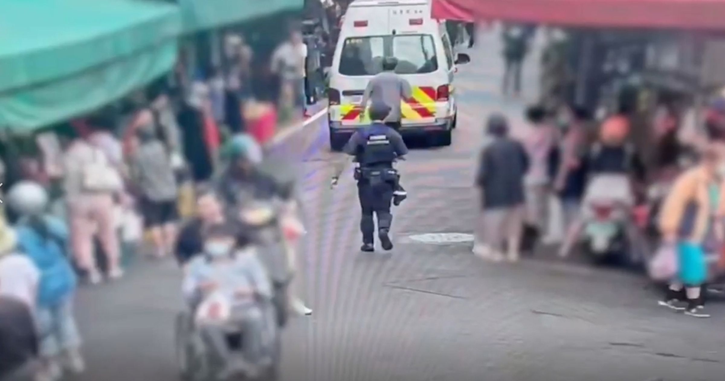 男子市場拿刀狂揮、咆哮自傷，員警迅速到場控制並戒護送醫。（警方提供）