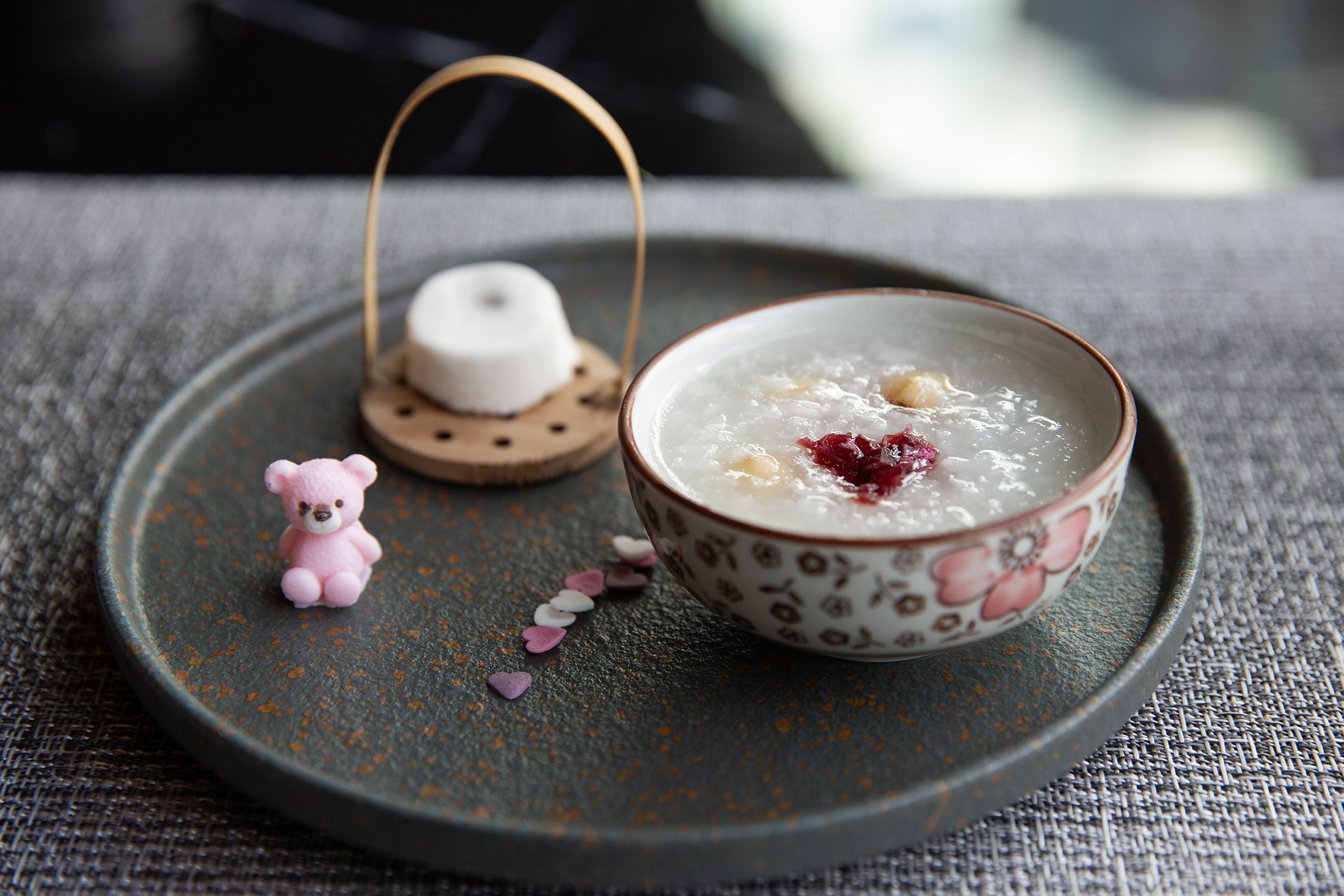 「赤豆糕．蓮心粥」來自張愛玲的《怨女》，使用糯米、紅豆、牛奶、糖製成鬆糕形狀的麵糰，口感軟熟且富層次，搭配糯米、糖和蓮子煲煮的白粥，一冷一熱，入口雖甜，卻能嘗到故事裡悲涼交加的獨特況味。
