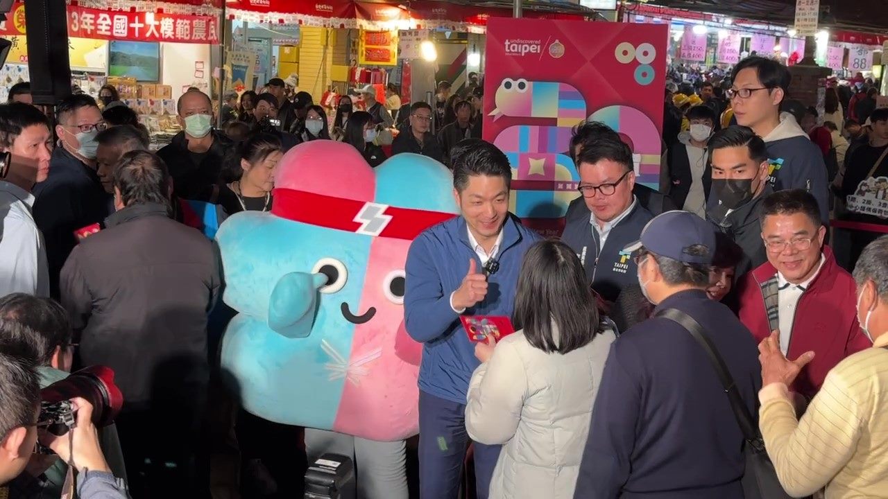 2025雙北世壯運吉祥物「壯寶」14日陪同台北市長蔣萬安在迪化街發送「年貨三十」蛇年限定發財金。（北市體育局提供）