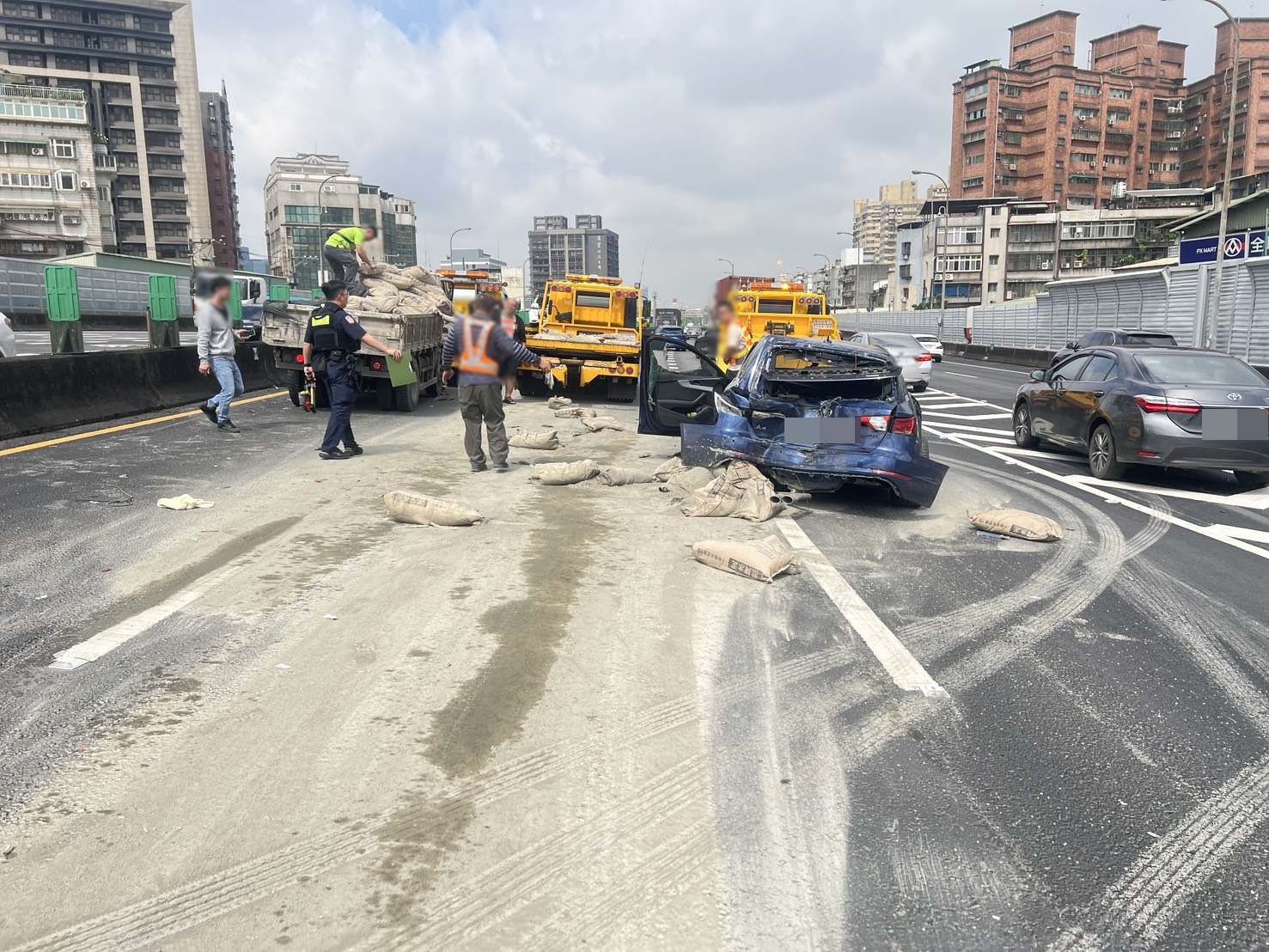 肇事的大貨車載運大量水泥包，事故現場散落大量水泥土，一度造成回堵。（翻攝畫面）