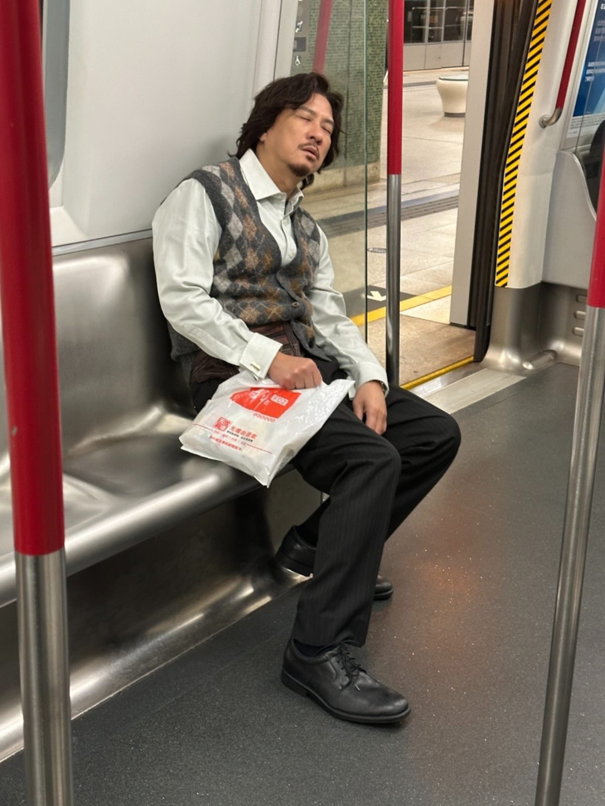 為了宣傳電影，張家輝打扮成片中角色「蔡辛強」的模樣在地鐵上累到睡過頭，故意被網友偷拍。（甲上提供）