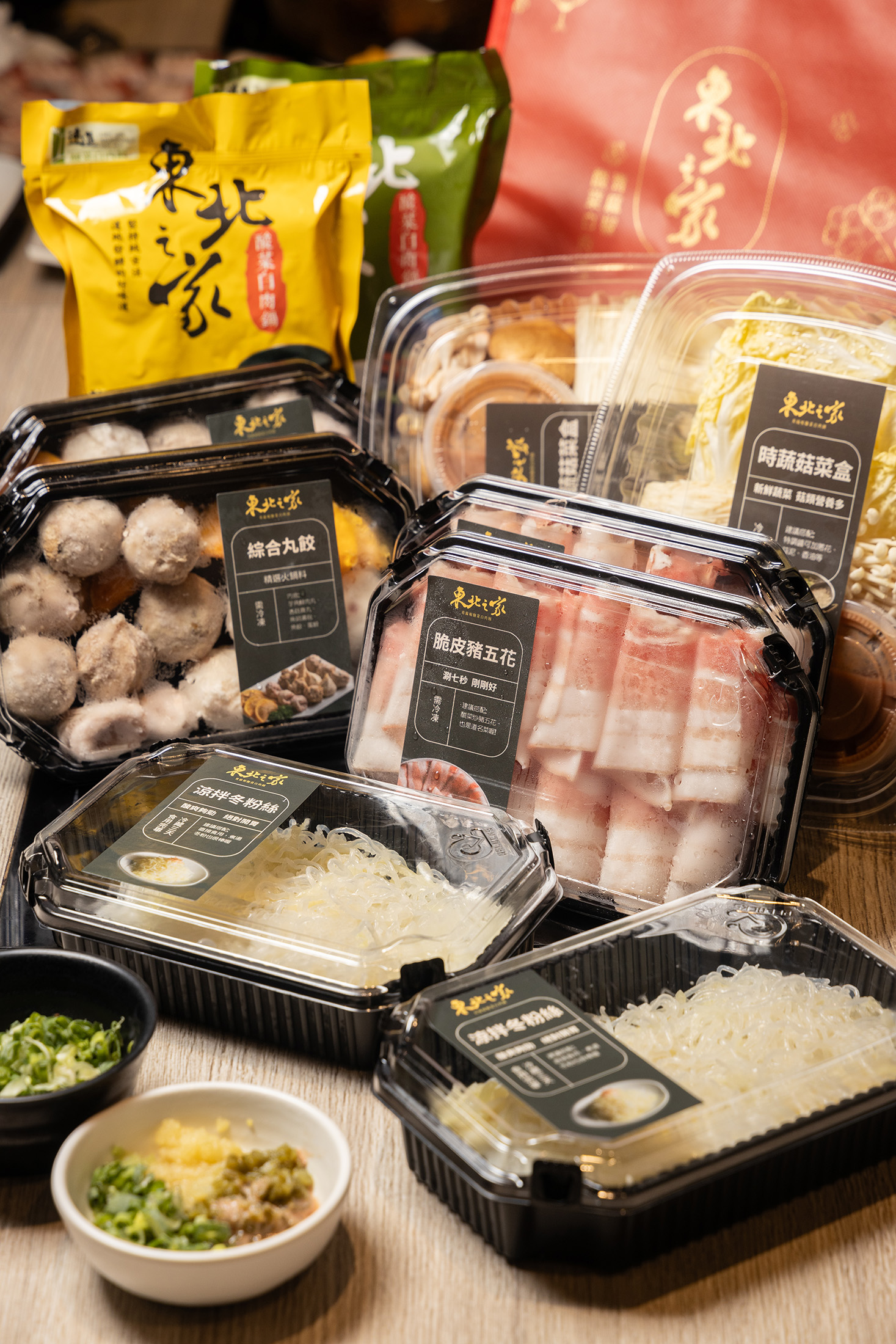 「東北之家酸菜白肉鍋」推出的「外帶四人組」，除了酸菜湯底，還能吃到招牌脆皮豬五花、綜合丸餃、時菇蔬菜盒、涼拌冬粉絲等肉品與配菜。（外帶火鍋組1,198元／組、約4～6人份）