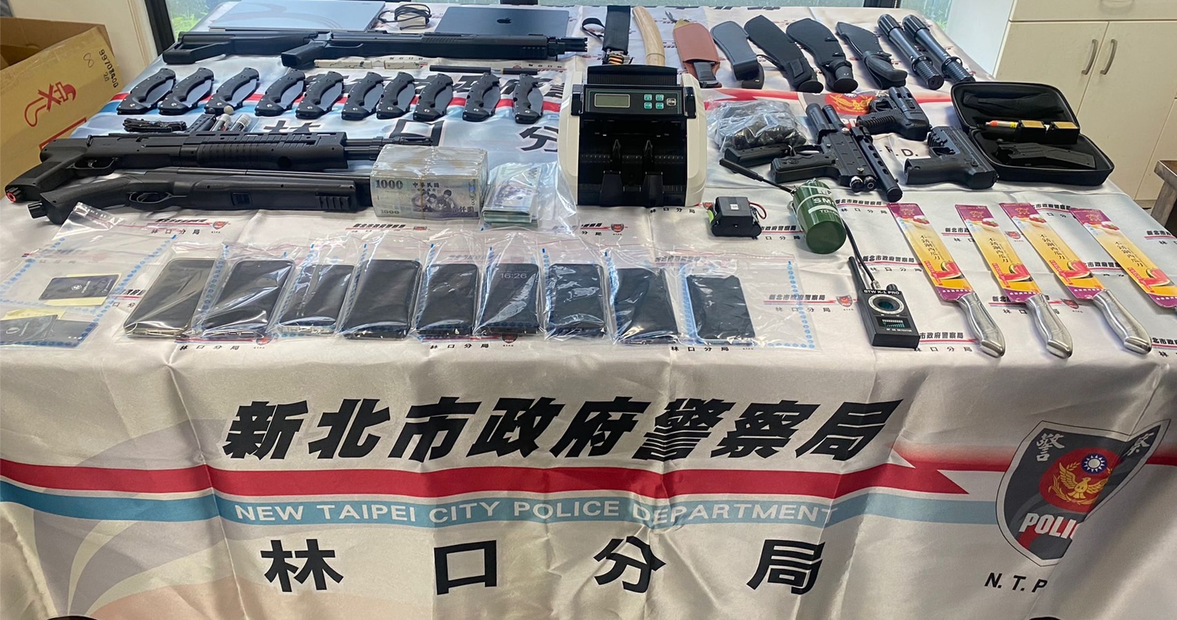警方當場查扣大量不法所得與犯罪工具，包括現金120萬元與鎮暴槍、模擬槍及各類刀械。（林口分局提供）