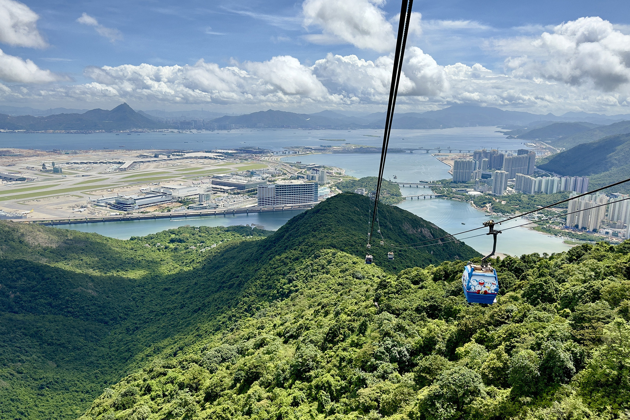 從纜車上可看到山與海交織的香港郊野景色，以及香港國際機場遼闊的視野。