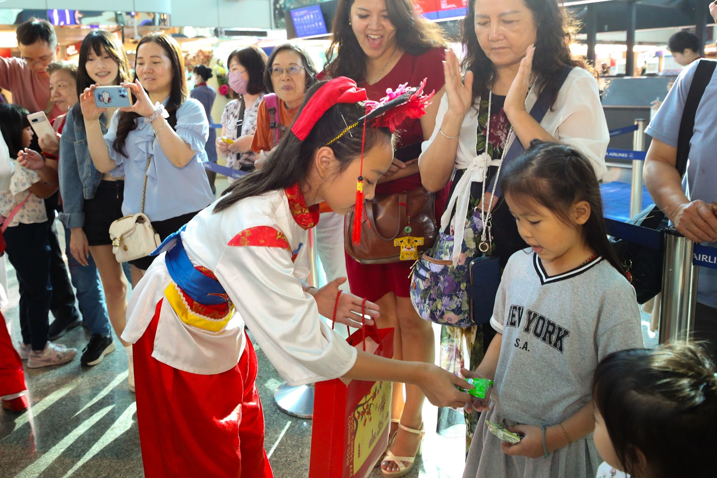 金門中正國小鼓吹隊員與旅客互動,分享來自金門的文化熱情。(財團法人昇恒昌基金會提供)