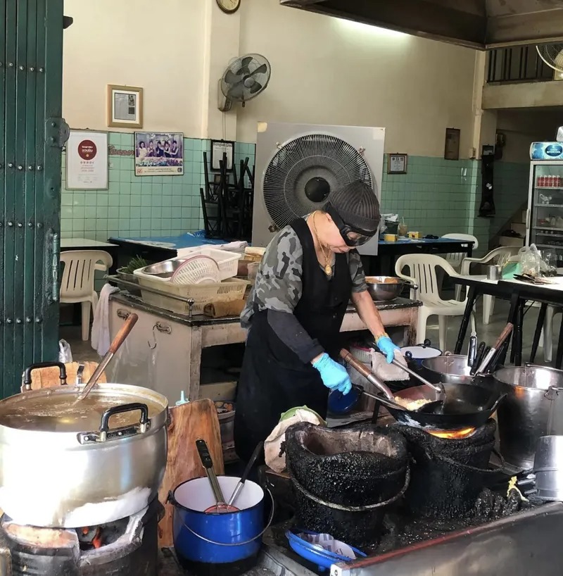 現年82歲的蘇賓雅(Supinya Junsuta),暱稱Jay Fai,憑著一手火焰螃蟹煎蛋,讓小吃店躍上米其林名單。(翻攝IG)