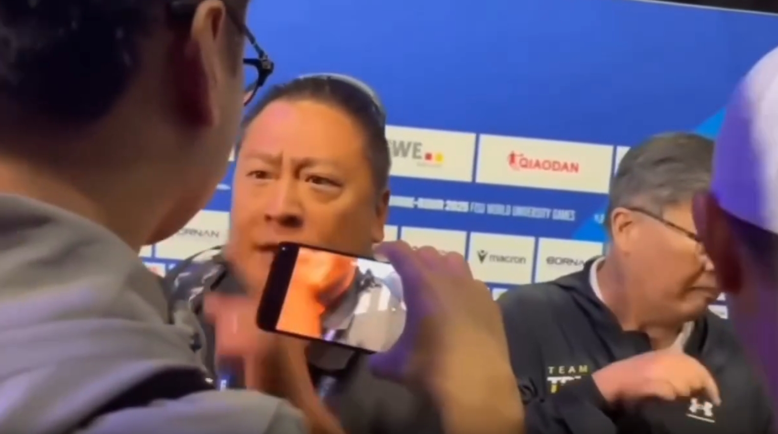 記者莊順發擋下試圖搶賀電鬧場的中國人員。（翻攝畫面）