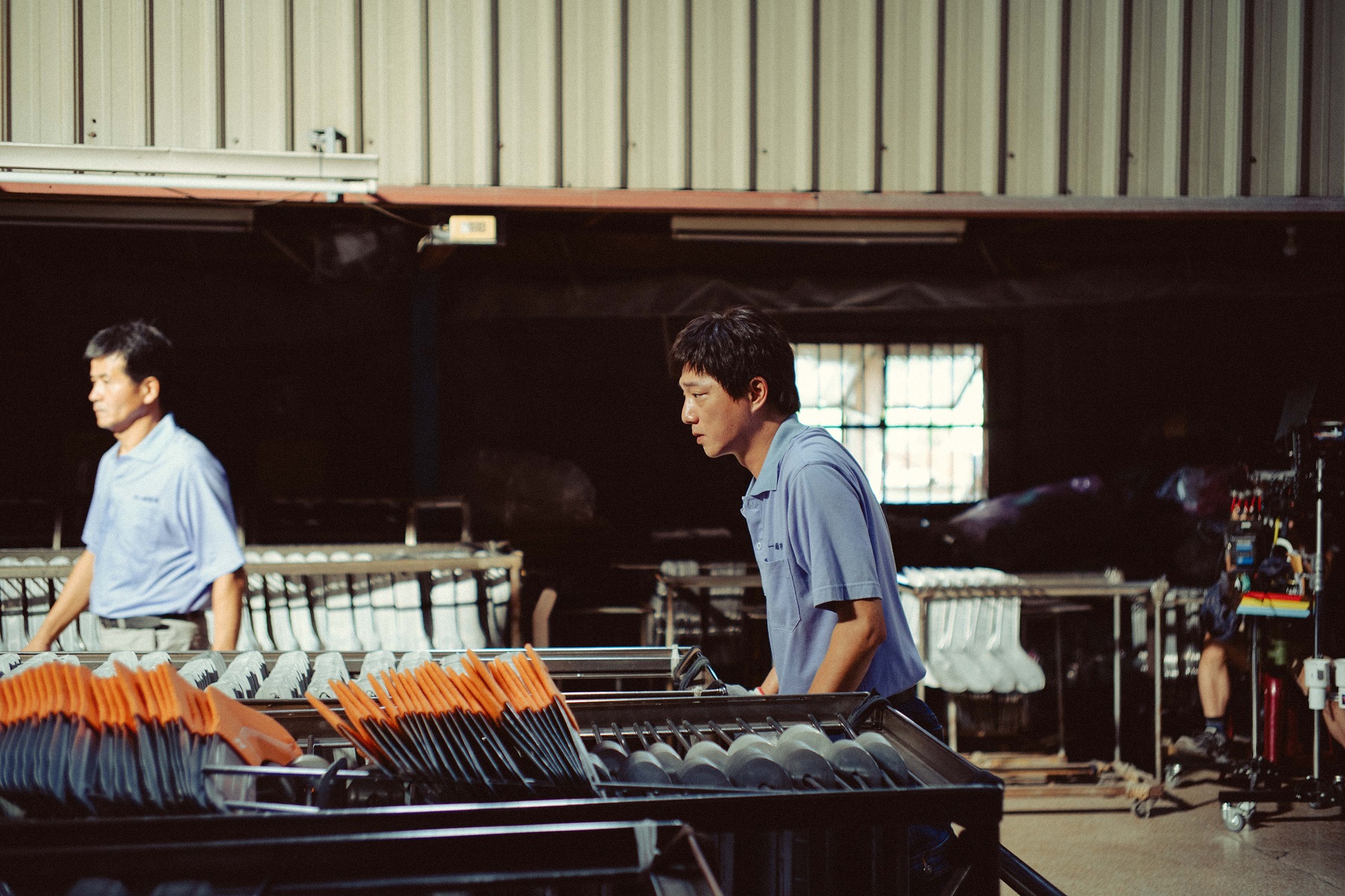 片中演員藍葦華（右）在彰化社頭襪子工廠工作的場景獲廠方支持。 （牽猴子提供）