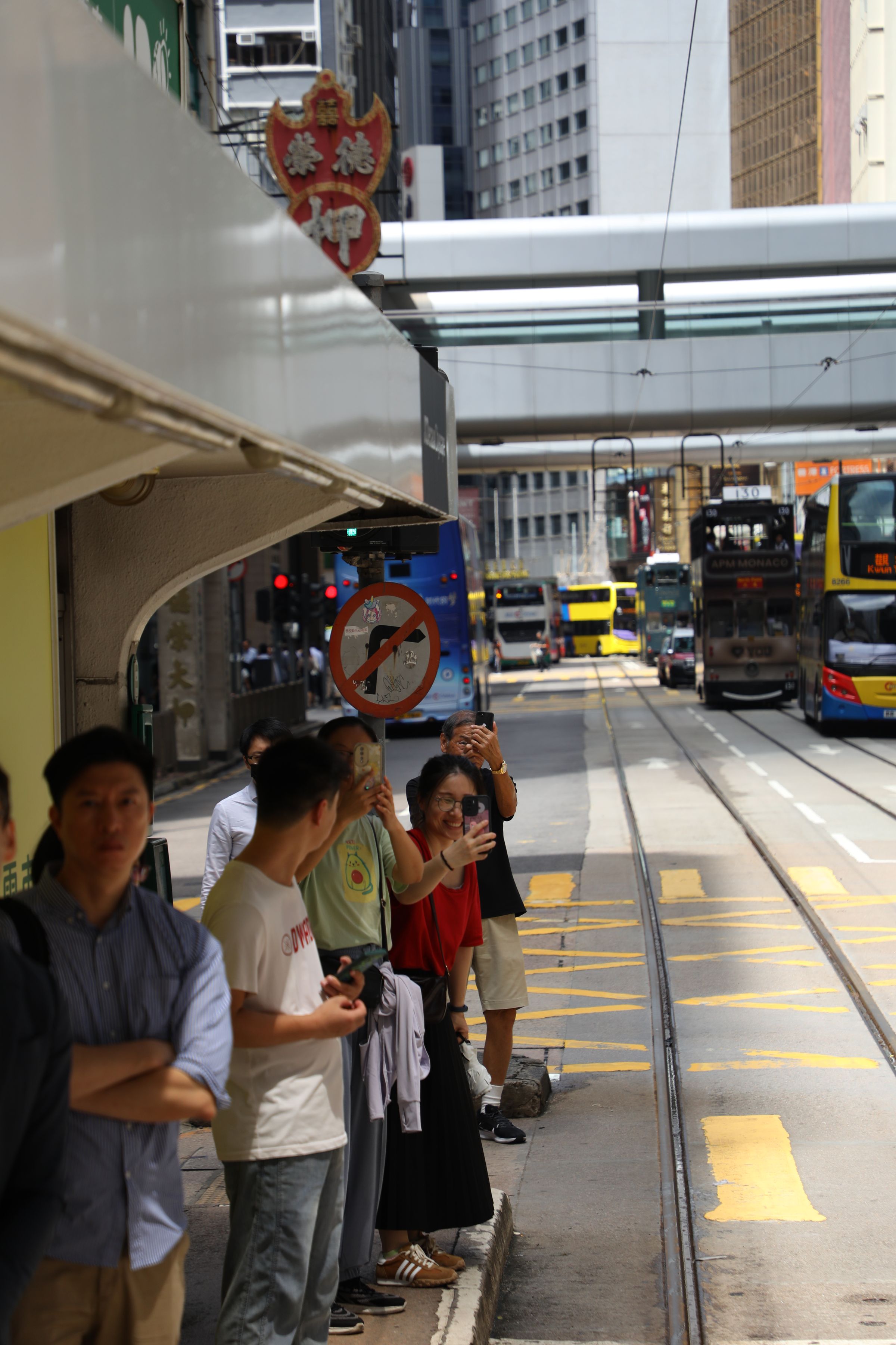 在電車站一邊等電車一邊笑著討論復古電車的乘客們。