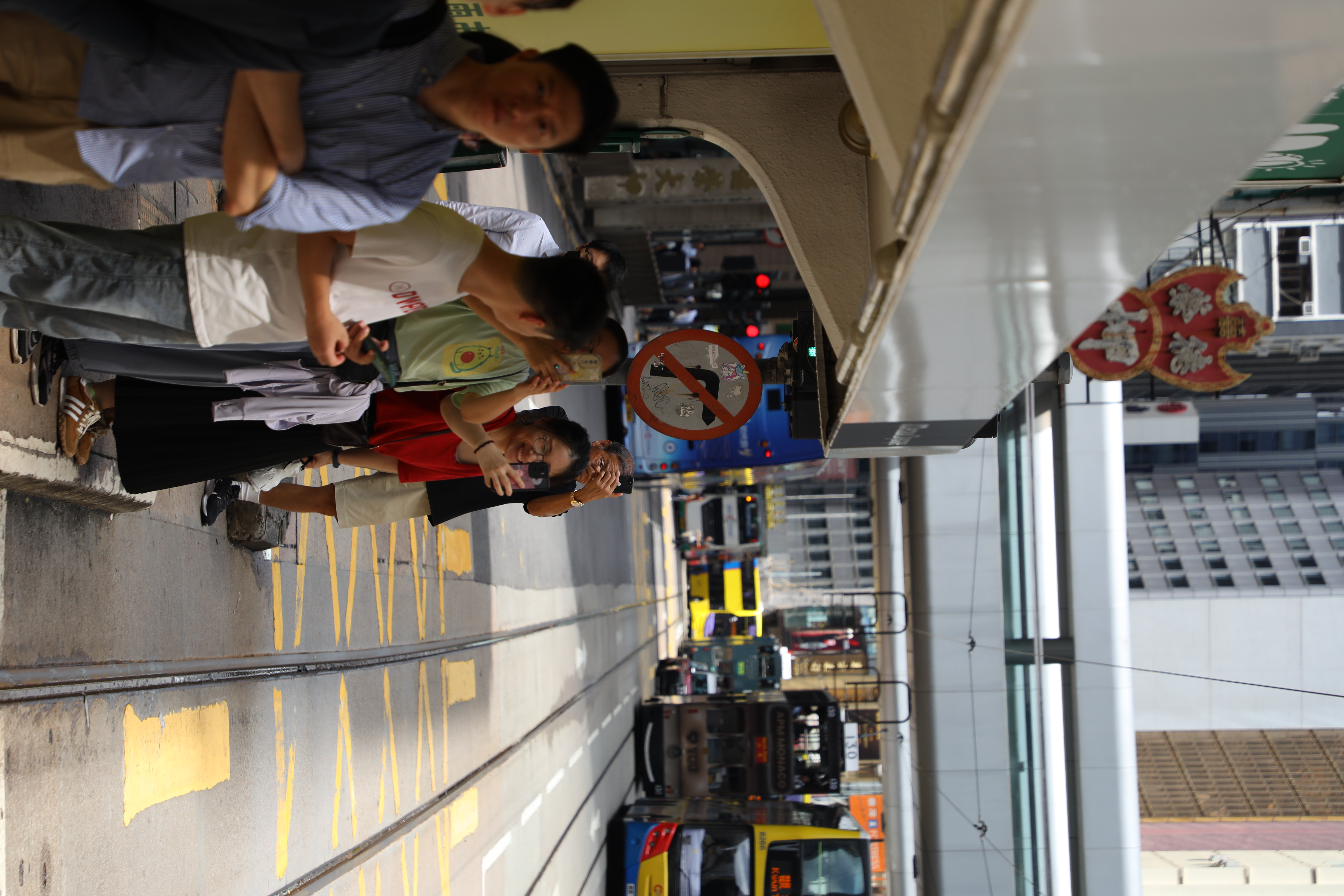 在電車站一邊等電車一邊笑著討論復古電車的乘客們。