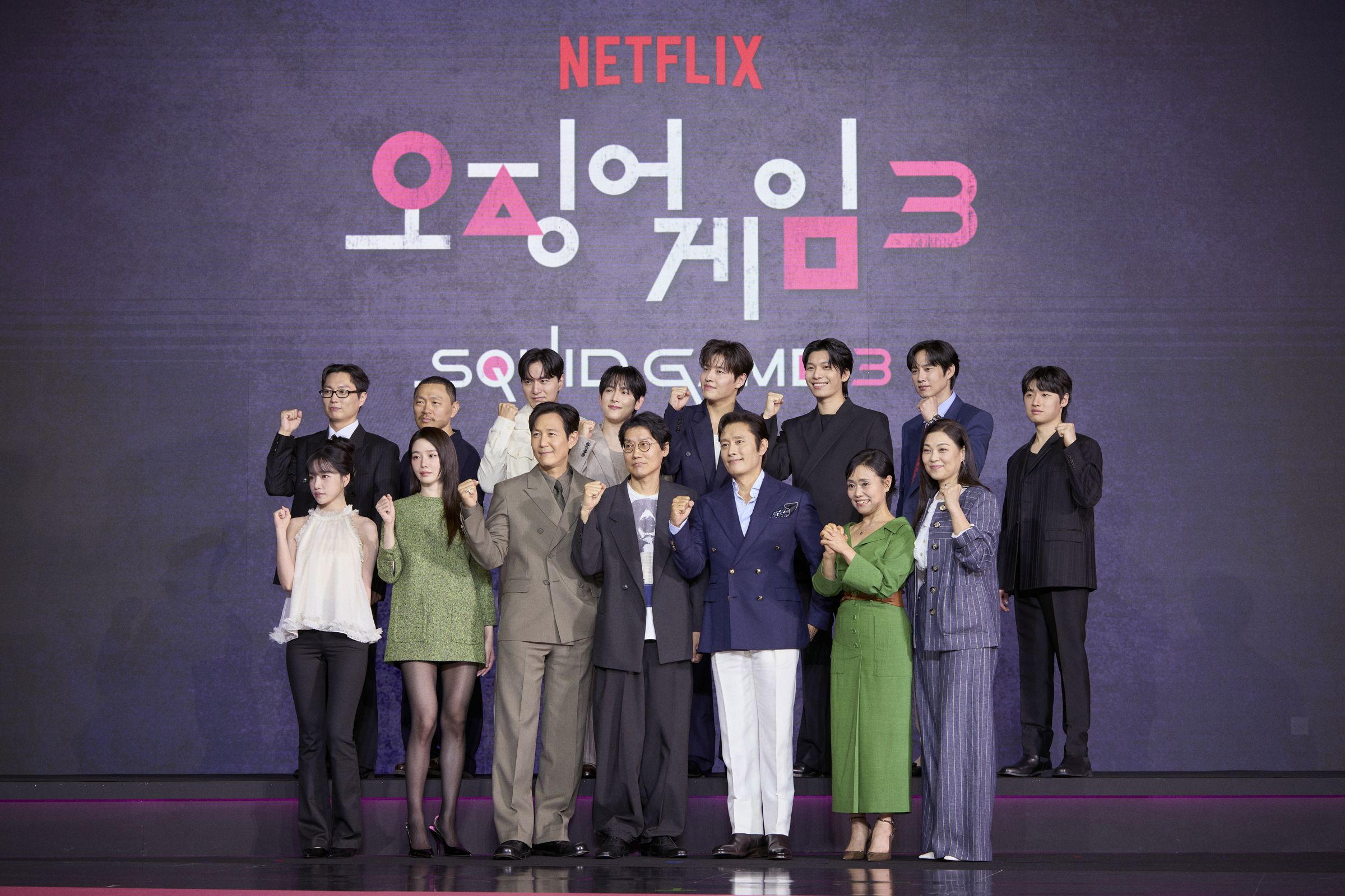 《魷魚遊戲3》導演率主演群共15人出席記者會,像極了畢業典禮。上排由左而右為盧載沅、梁東根、李陣郁、任時完、姜河那、魏嘏雋、朴成焄、李大衛;下排由左而右為曹柔理、朴珪瑛、李政宰、導演黃東赫、李炳憲、康愛心。(Netflix提供)