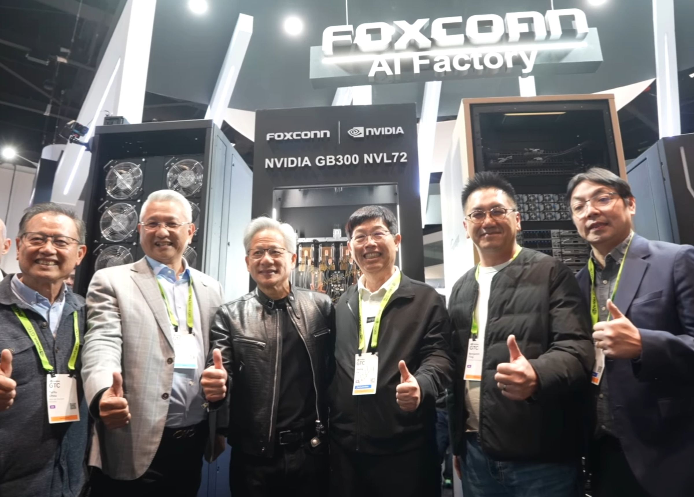 黃仁勳參觀鴻海GTC展位，在GB300 NVL72伺服器機櫃上簽名，劉揚偉隨後從一台機櫃中抽取一盒「鴻海巧克力」致贈，兩人合照留念。（翻攝自鴻海科技集團臉書）