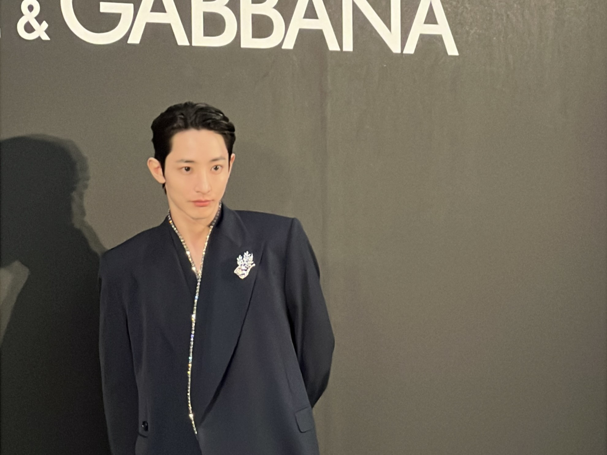 李洙赫穿著Dolce&Gabbana標誌性設計大劍領西裝、搭配超寬鬆黑色長褲出席旗艦店開幕記者會。