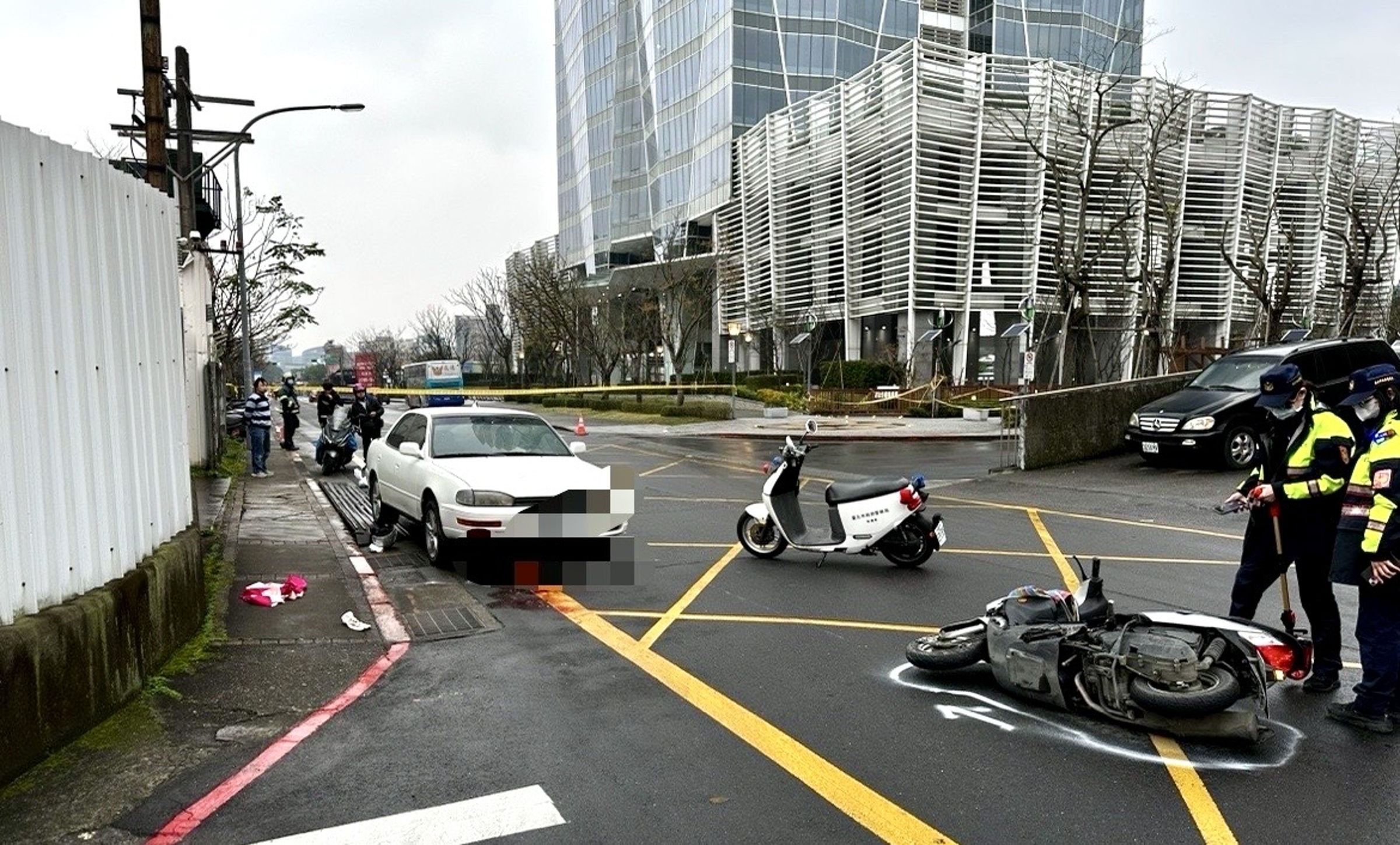 黃姓機車騎士在路口撞到等待左轉的重機後倒地，遭後方轎車輾過重傷。（翻攝畫面）