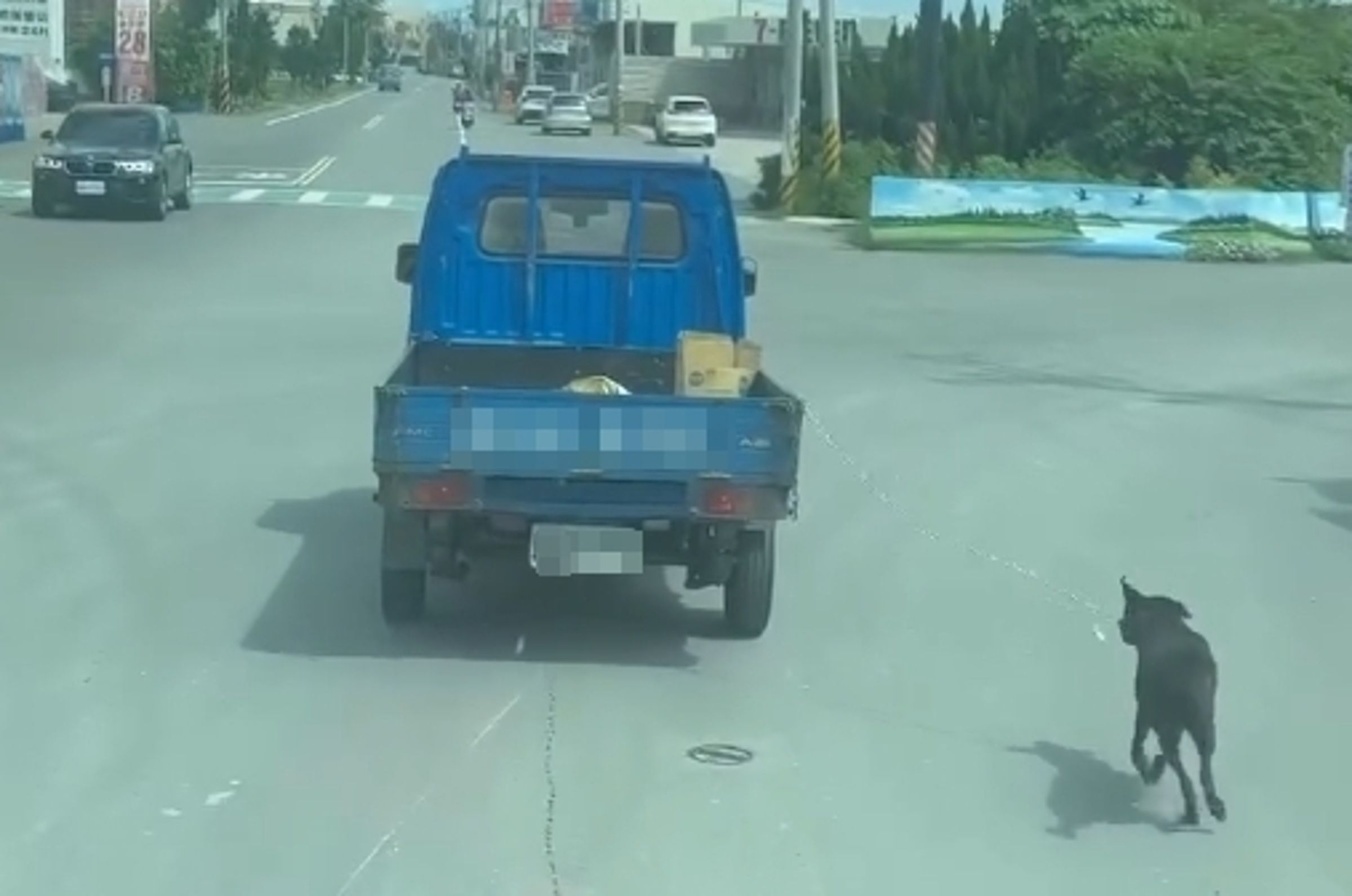 彰化路上驚見一隻狗狗被用鐵鍊綁在小貨車車尾,牠沿路奔跑追車,畫面在網上曝光後,留言區掀起網友一片罵聲。(翻攝自Threads @bi3260)