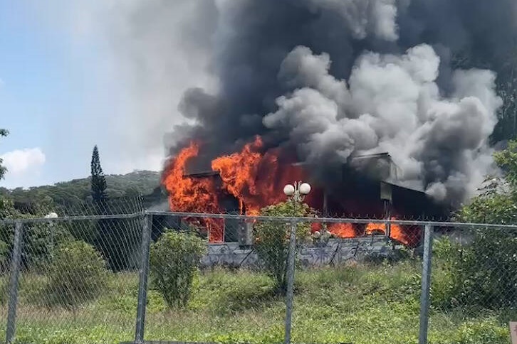 消防人員抵達現場時，整棟平房已經陷入火海，濃煙密佈，清理火場時，驚見女屋主抱著2條狗，葬身火窟。（翻攝畫面）