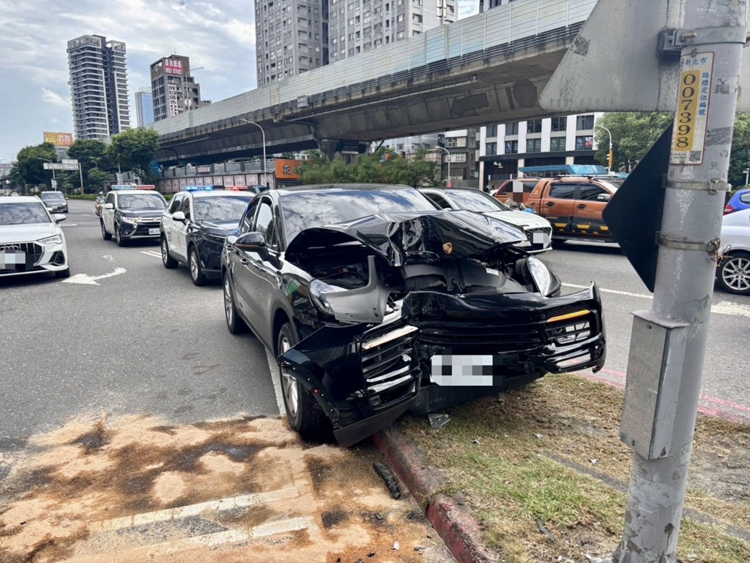 洪姓男子駕駛黑色保時捷在板橋區自撞路邊燈桿，造成車頭嚴重凹陷，警方查出洪男毒品快篩呈現陽性反應。（翻攝畫面）