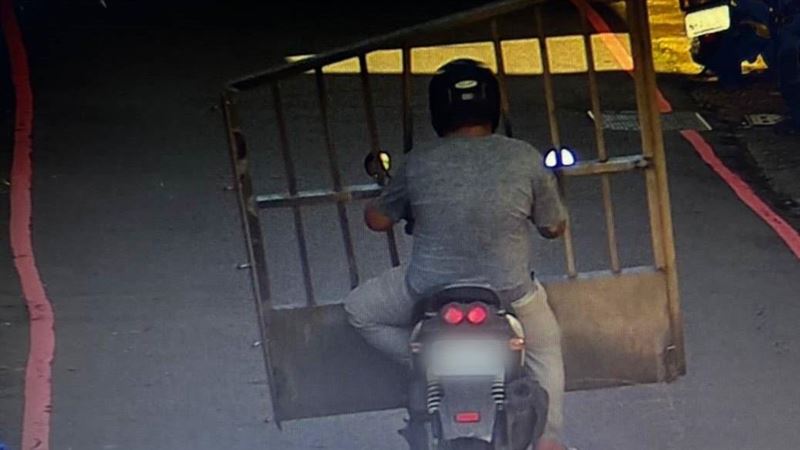 1名男子竟在大白天騎車前往球場側門,當街持砂輪機切割白鐵格柵門,接著直接將整扇鐵門扛上機車載走。(翻攝畫面)