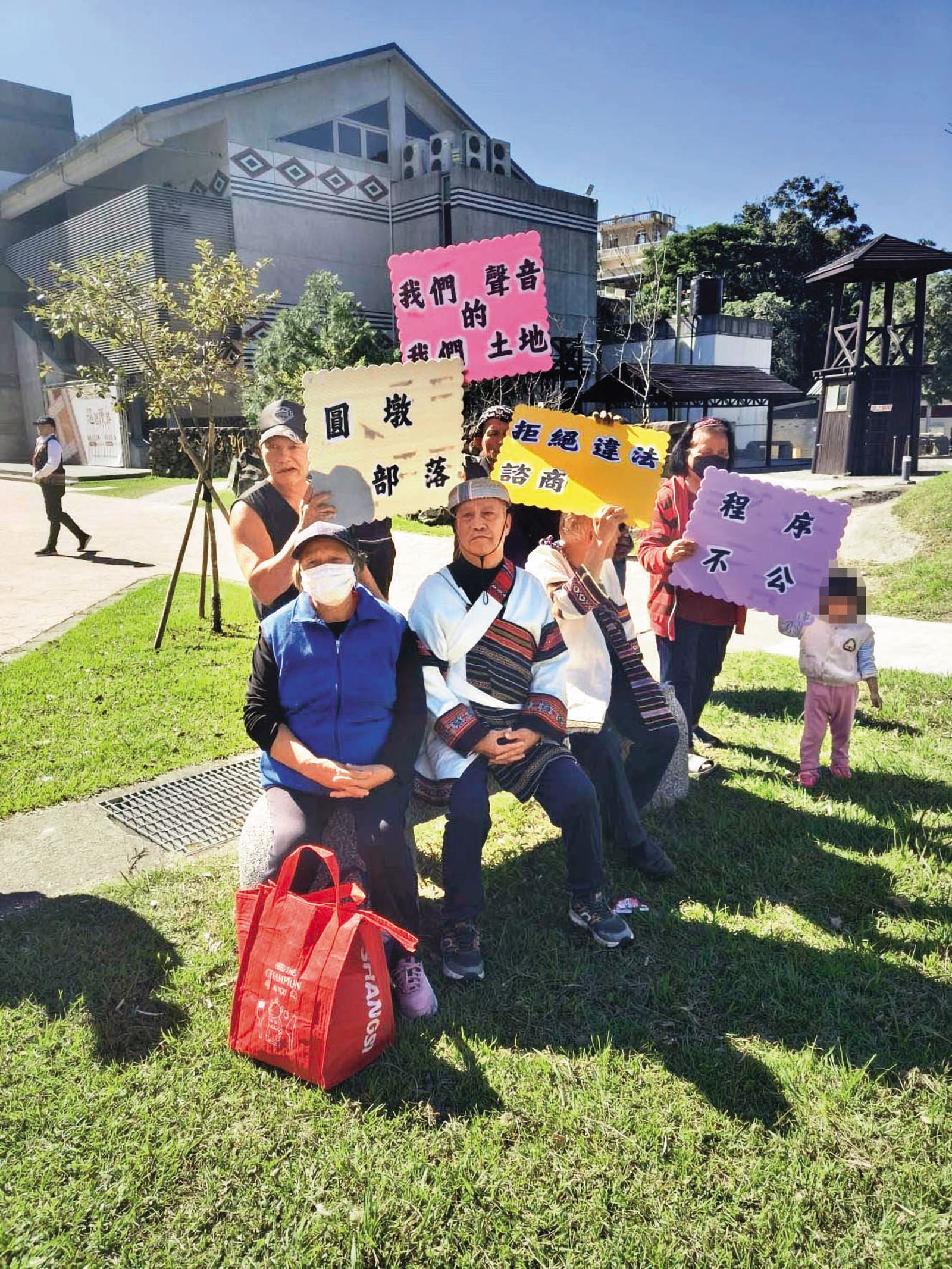 圓墩部落居民手舉看板，抗議財團涉及違法開發，苗栗縣府竟默許。（翻攝盧光明臉書）