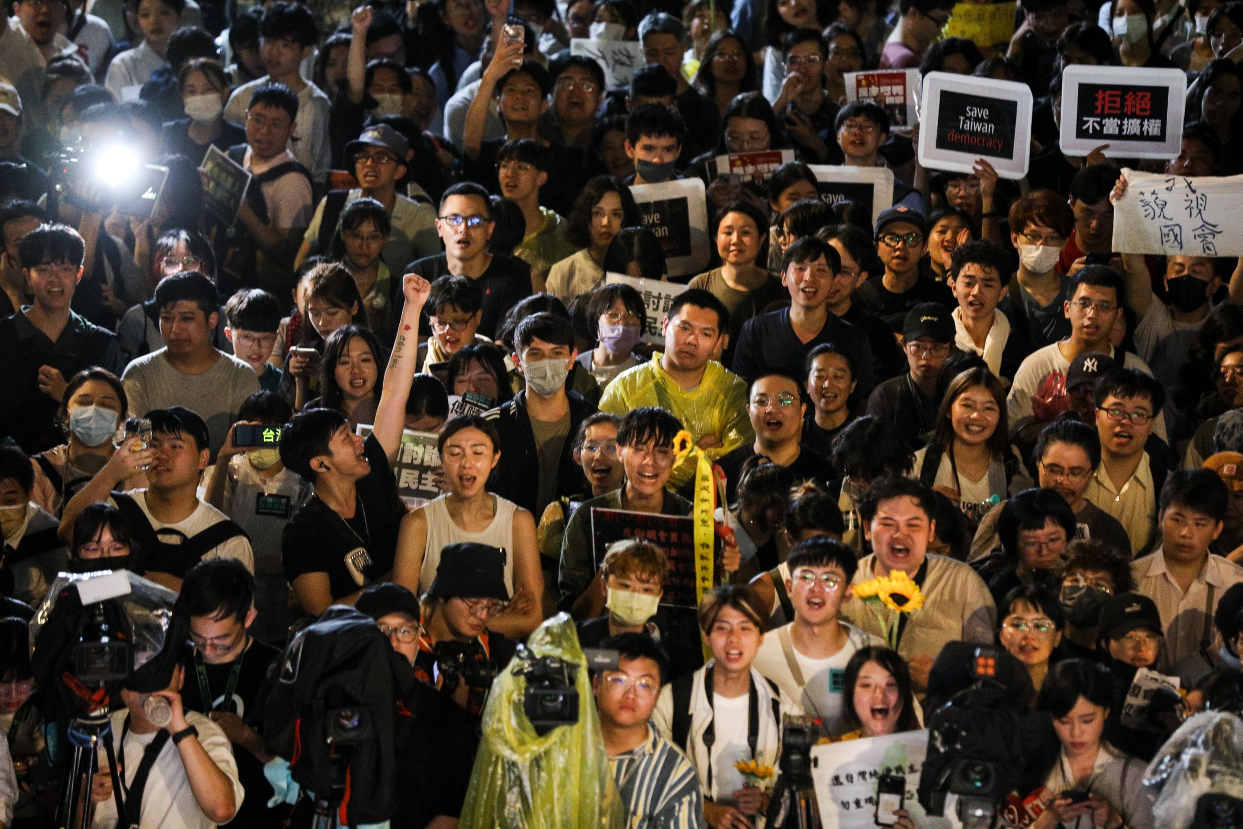 民眾舉牌「拒絕擴權」，或拿太陽花抗議。