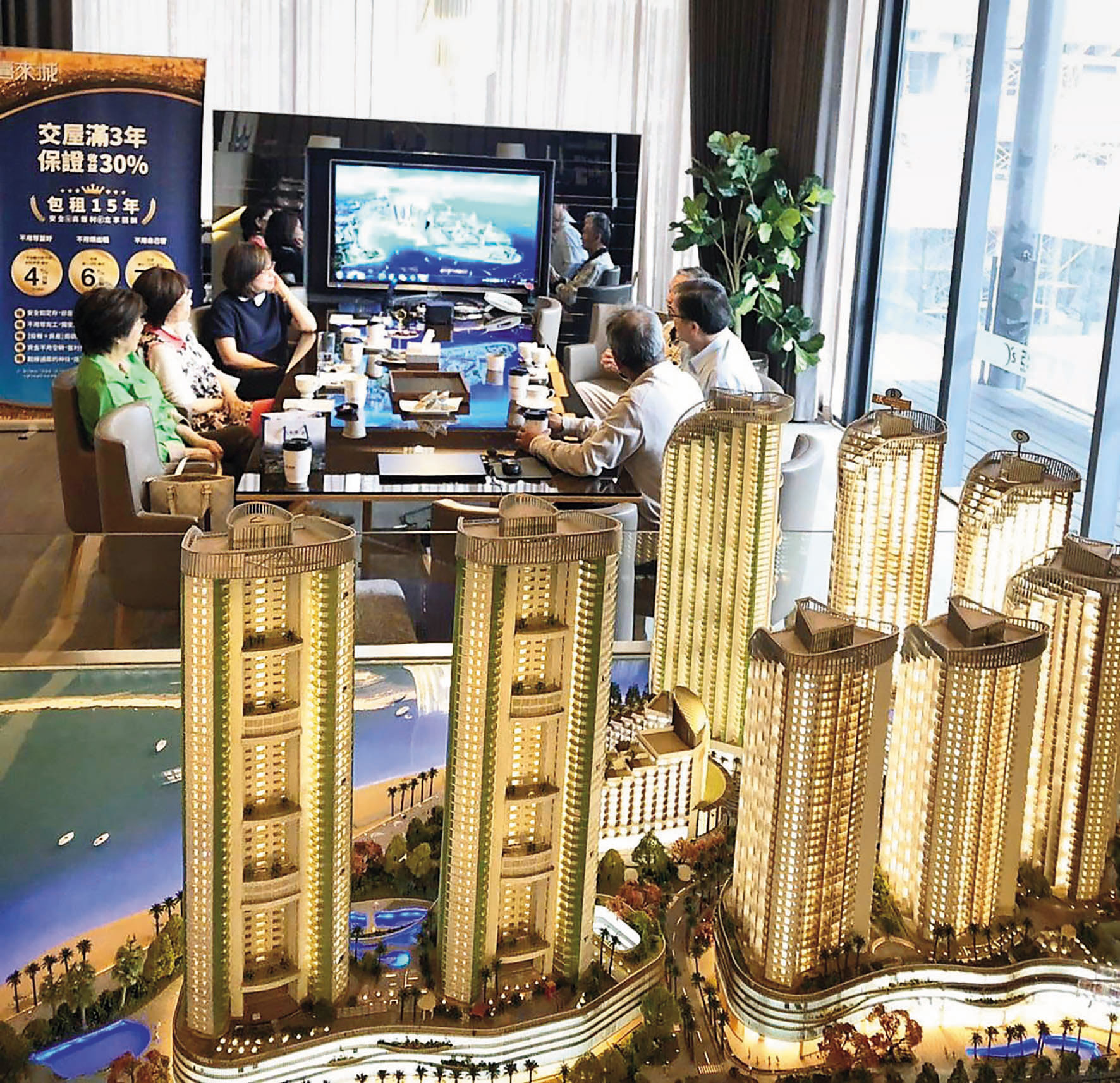 亞昕The Rise銷售中心展示模型，現場接待人員向客戶介紹建案。