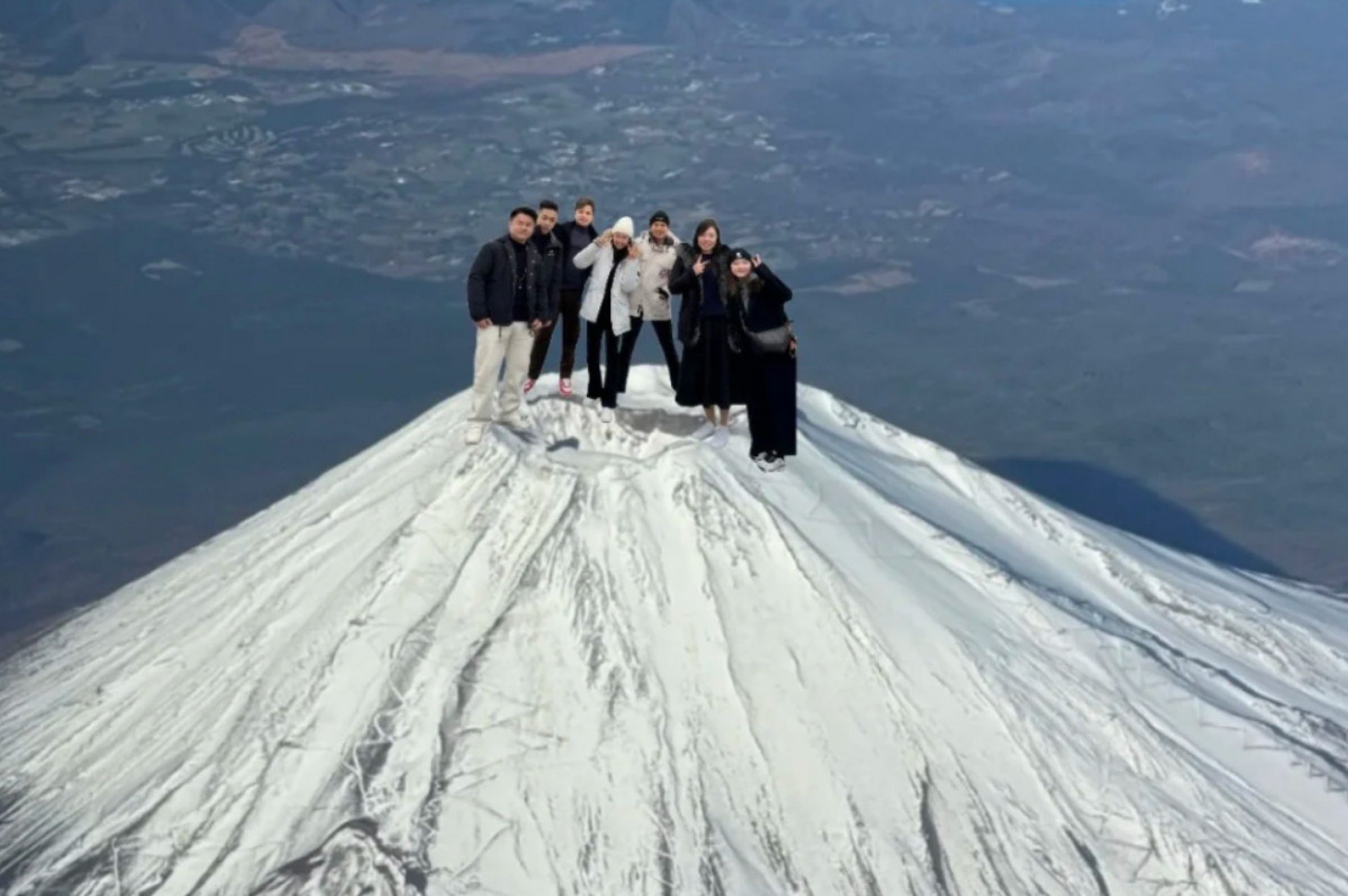 中國網友炫耀登頂富士山,可是照片比例失真,被網友嘲笑每個人都是巨人。(翻攝微博)