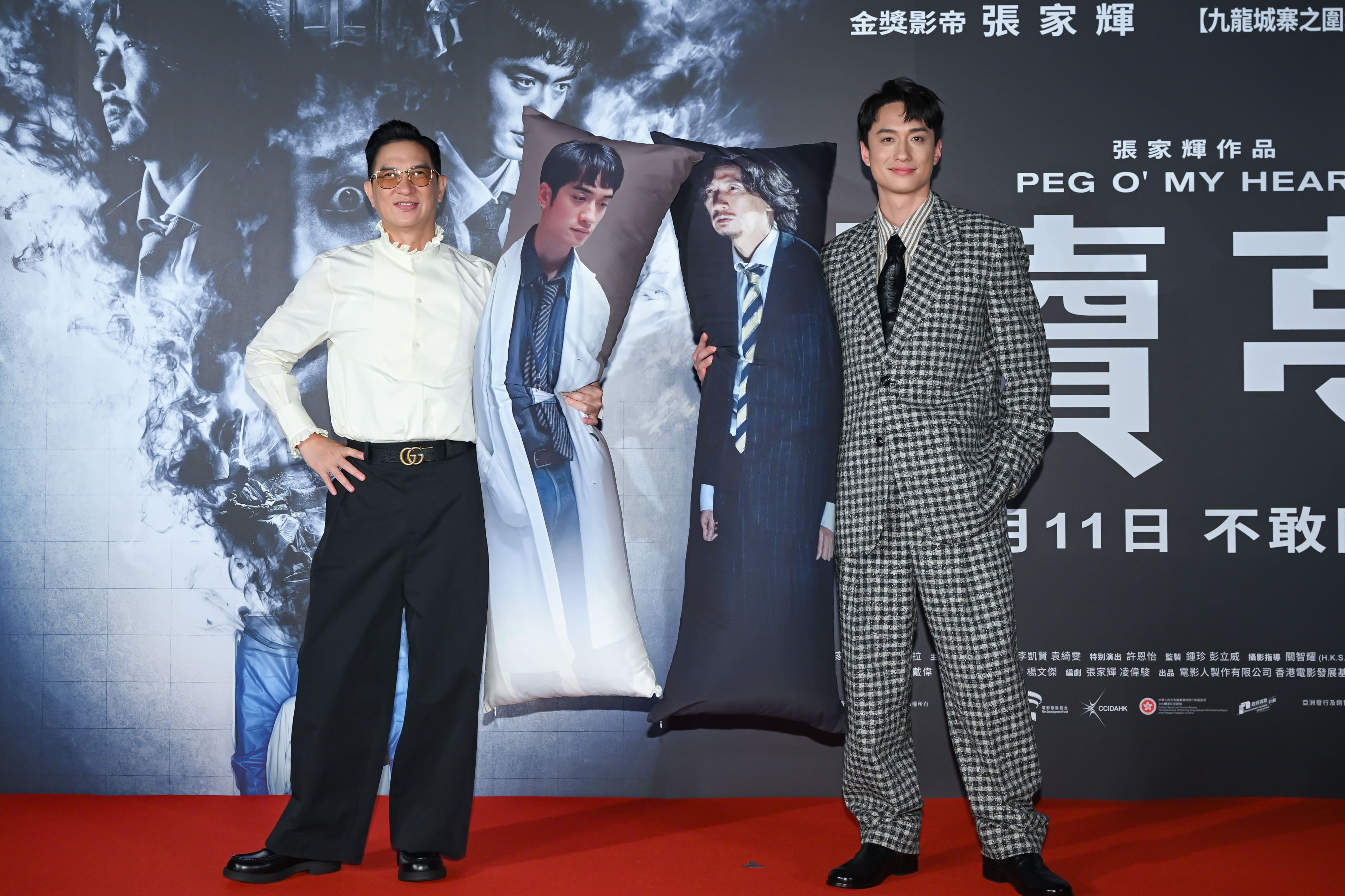 張家輝（左）與劉俊謙（右）互相拿著對方在《贖夢》裡的等比例人物抱枕。（甲上娛樂提供）