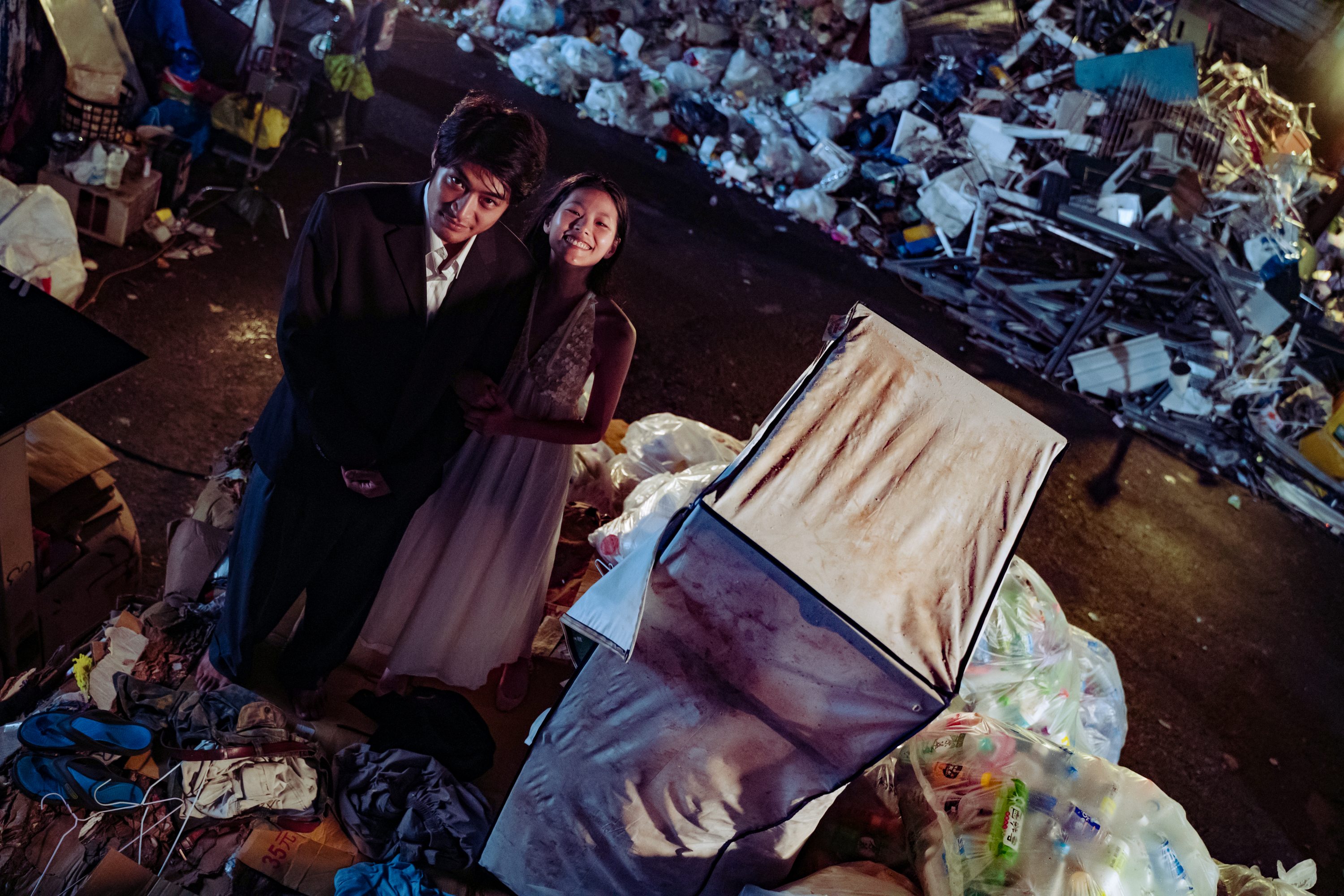潘綱大與柯泯薰在垃圾回收場拿丟棄舊衣玩角色扮演遊戲，但當時地上有不少蟑螂老鼠橫行。（底噪影像提供）
