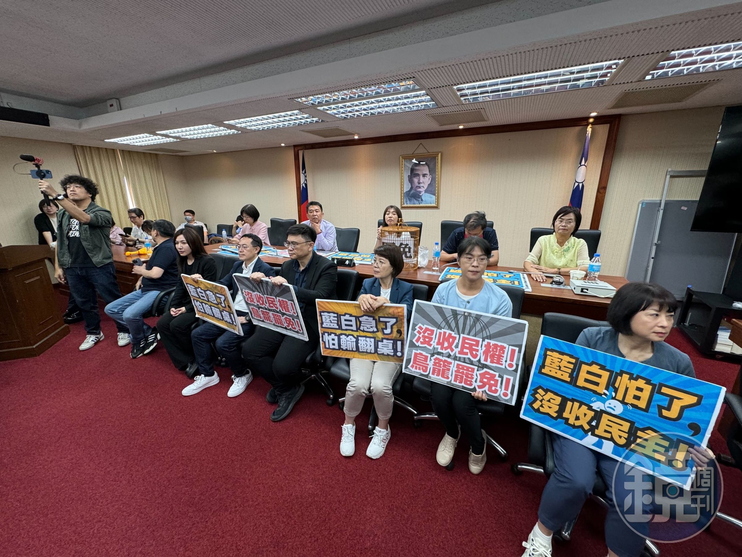 立法院內政委員會今排審「公職人員選舉罷免法修正草案」,民進黨立委拿出手舉牌,強烈反對將罷免門檻提高。