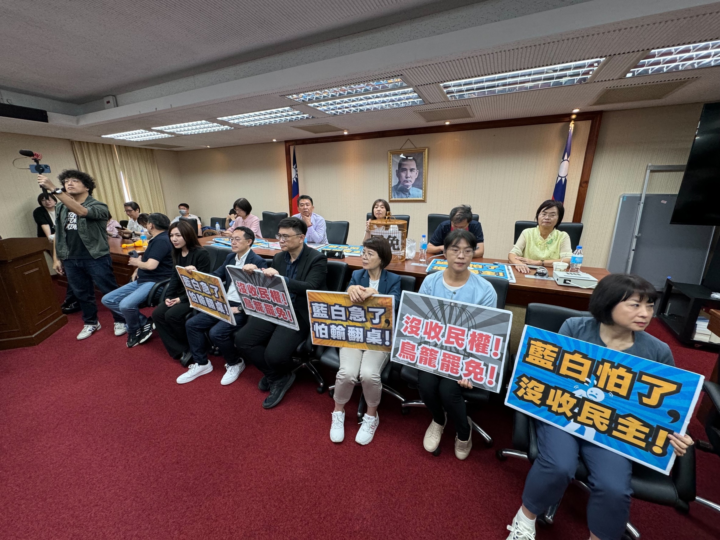 立法院內政委員會今排審「公職人員選舉罷免法修正草案」，民進黨立委拿出手舉牌，強烈反對將罷免門檻提高。