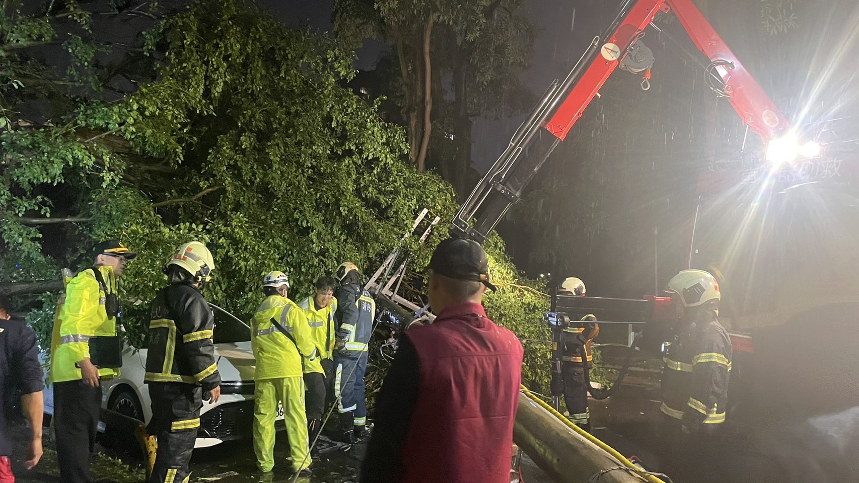 警消利用吊臂及破壞工具將被壓在電線桿下的羅男救出。(翻攝畫面)
