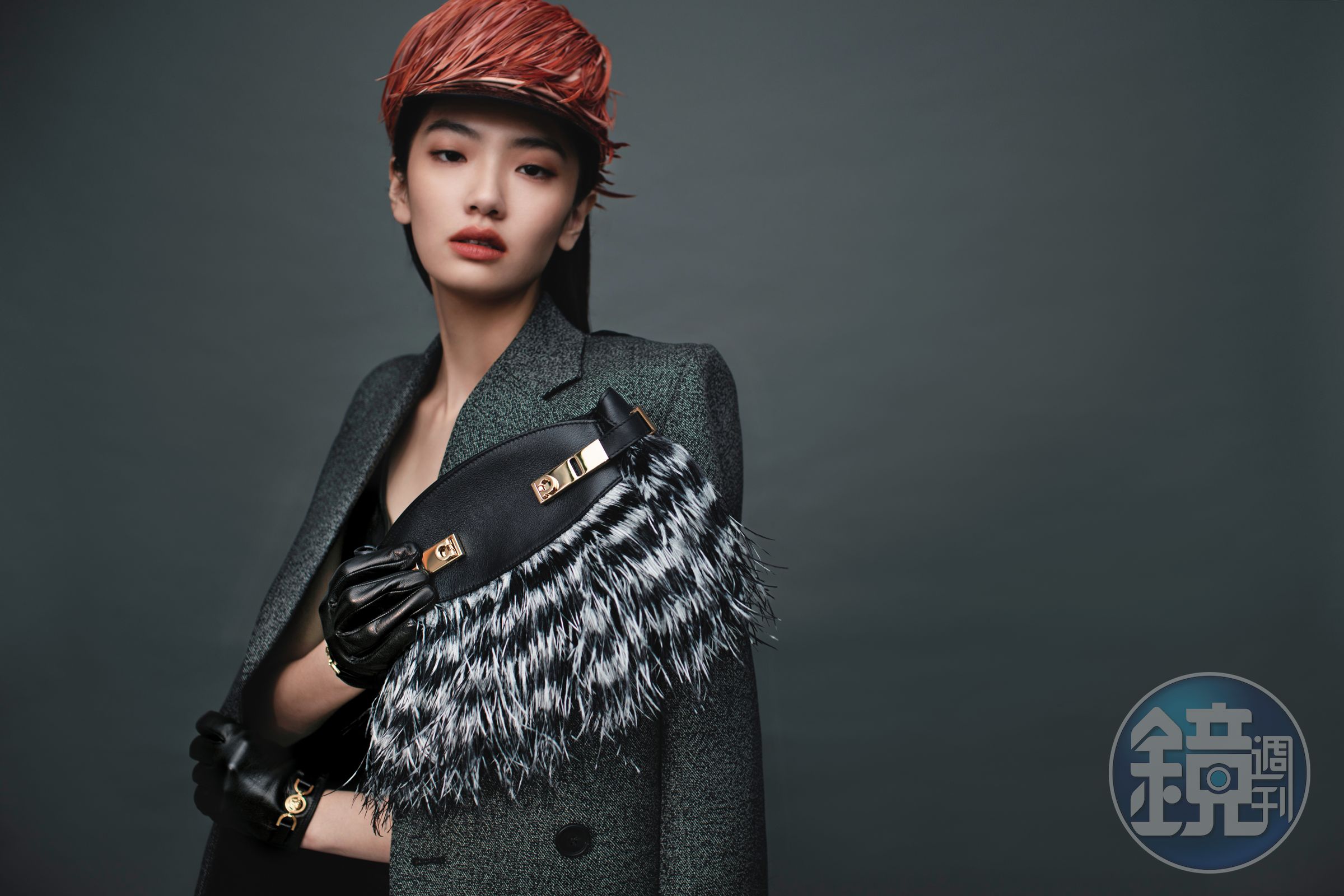 黑白毛絨跳色HUG手拿包 NT$123,000 by FERRAGAMO；羊毛西裝外套 NT$150,000 by PRADA；貼身皮洋裝 價格店洽 by VERSACE；漆皮羽毛帽 NT$110,000 by PRADA；皮革手套 價格店洽 by VERSACE。