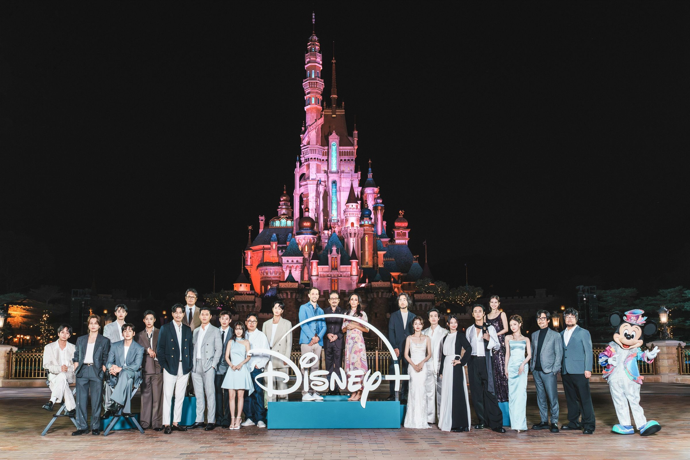 串流平台Disney+原創內容發布會今年移師至香港迪士尼度假區舉行,參與原創作品的日、韓、美影人在園區內城堡前與米奇留影。(Disney+提供)