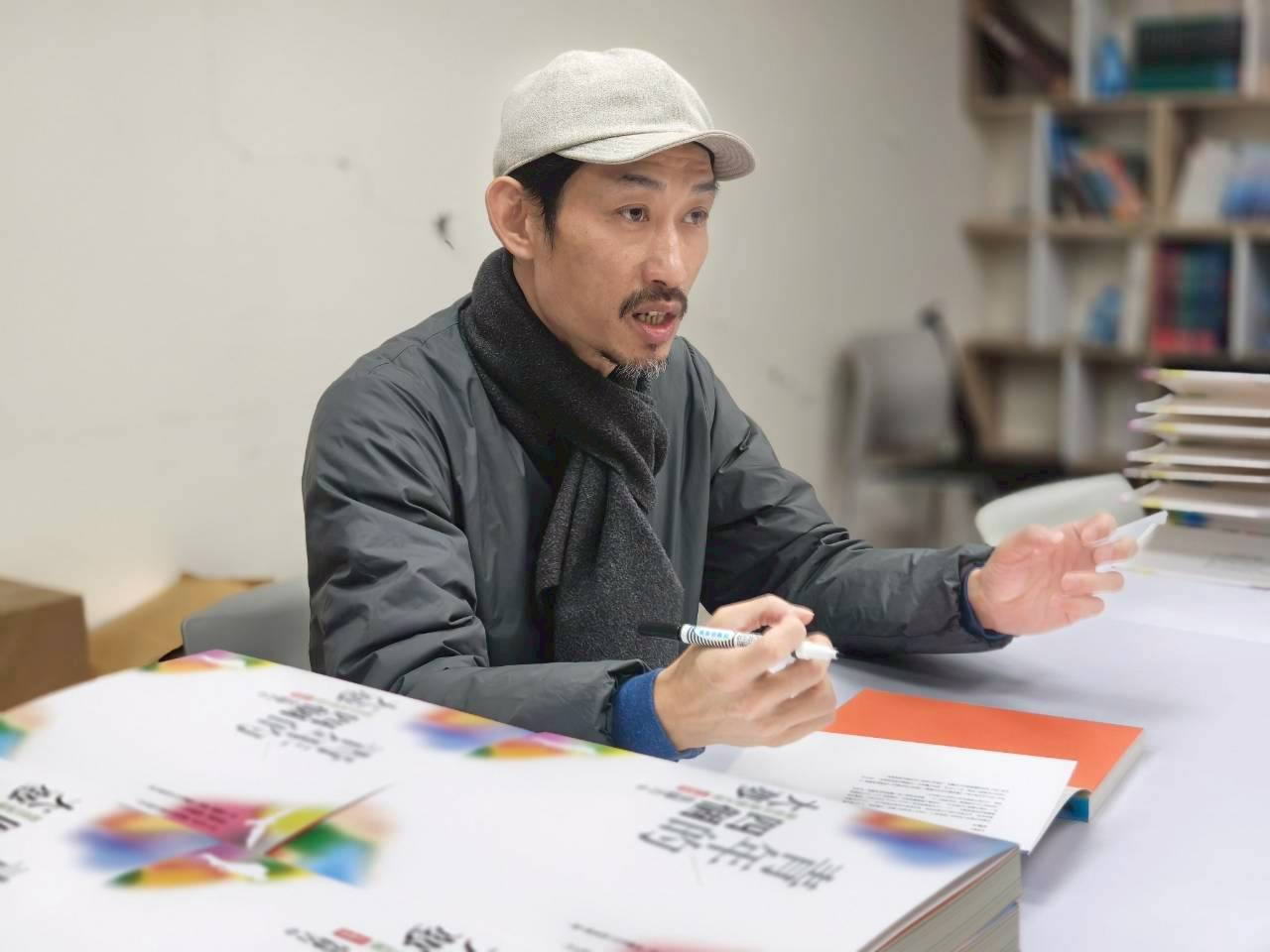 陳竹昇簽書簽到手抖，仍開玩笑說：「李永豐絕對是我的七世孽緣，但遇到紙風車這群良師益友，成為我一生的底氣。」（紙風車劇團提供）