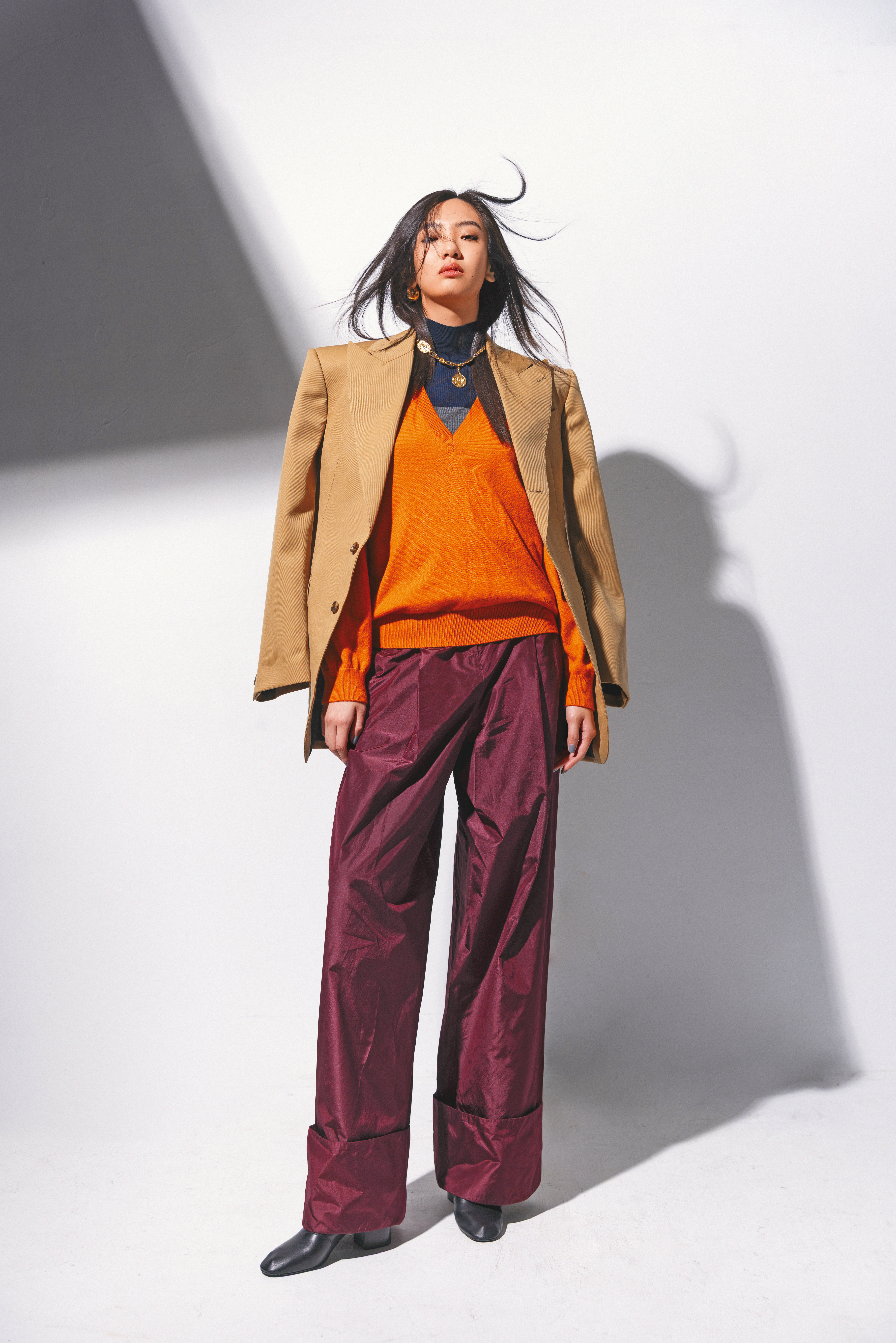 COLONNE夾克 NT$112,000 by CELINE；橙色羊絨毛衣 NT$61,200 by FENDI；雙色（深灰色／藍色）高領衣 NT$36,900 by FERRAGAMO；勃根地酒紅色塔夫綢長褲 NT$78,000 by FENDI；羊皮革短靴 價格店洽 by CELINE；GUCCI Bondie系列耳環 NT$30,700 by GUCCI；金色項鍊 價格店洽 by Chloé。