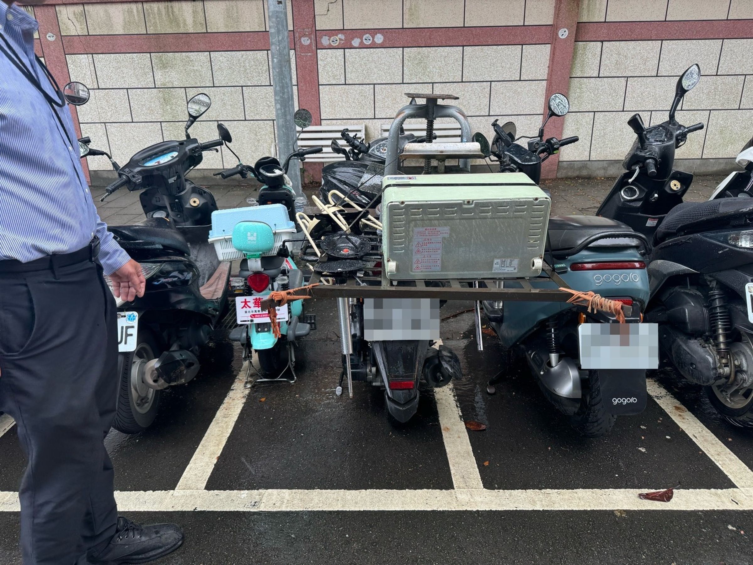 停放在機車格內的機車,因後方載運鐵架過長,導致行經轎車被刮傷。翻攝畫面