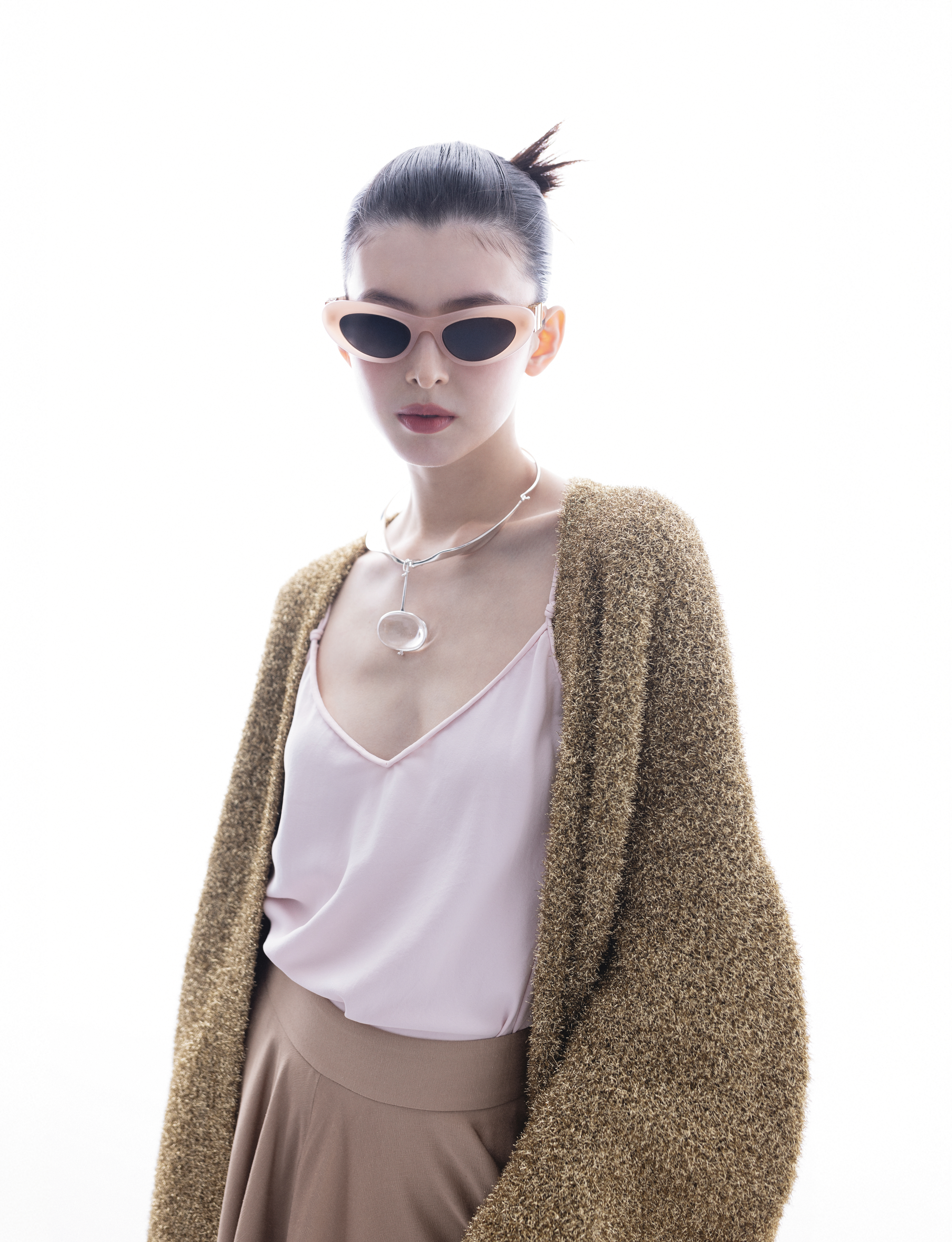 金色金銀紗混紡針織長外套  NT$119,000 by LOEWE／Lacey上衣 價格店洽 by Loro Piana／Jarrett長褲 NT$153,100 by Loro Piana／淺粉紅超薄結構貓眼形太陽眼鏡 NT$11,350 by LOEWE／Vivianna Torun Celebration純銀水晶項鍊 NT$59,000 by GEORG JENSEN
