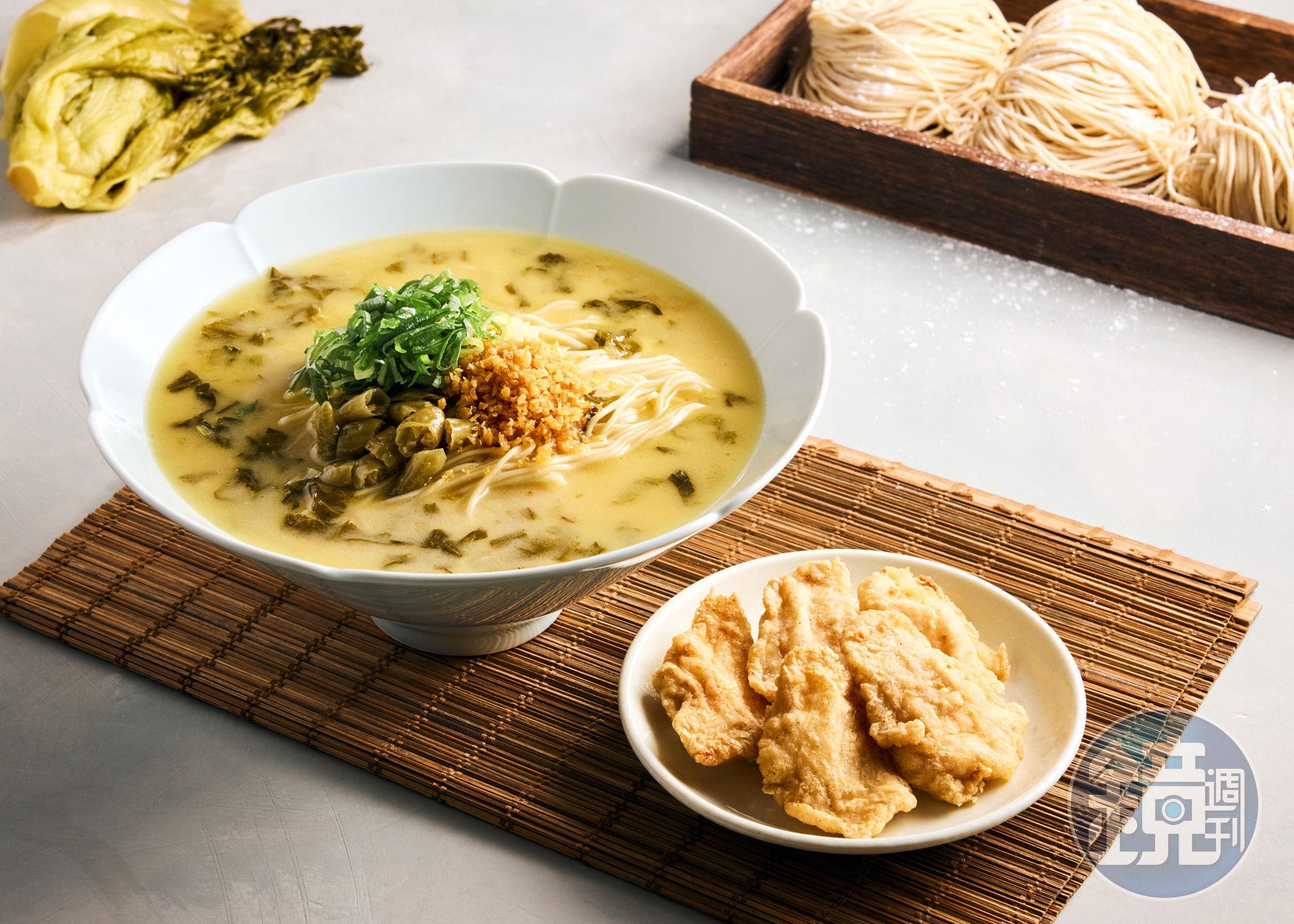 「酸菜金黃魚片雞白湯麵」湯汁辛口、尾韻香甜，油炸的多利魚片，外酥內軟。（288元／碗，圖片由樂蝦拉麵提供）