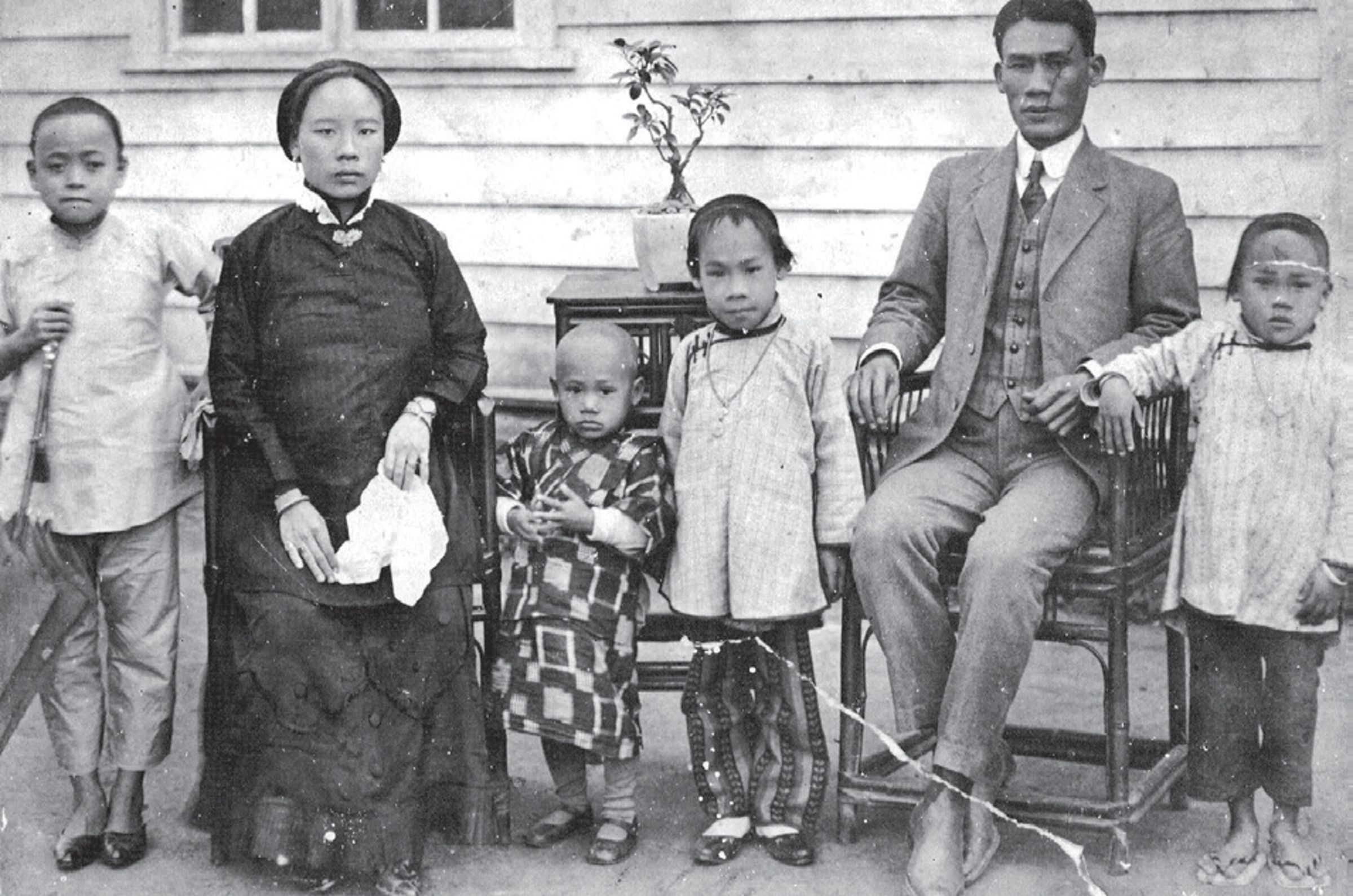 1910年代後期家庭的合照。婦女上身穿中式服、下著西式裙,男士穿著及髮型皆為西式。(圖/葉立誠)