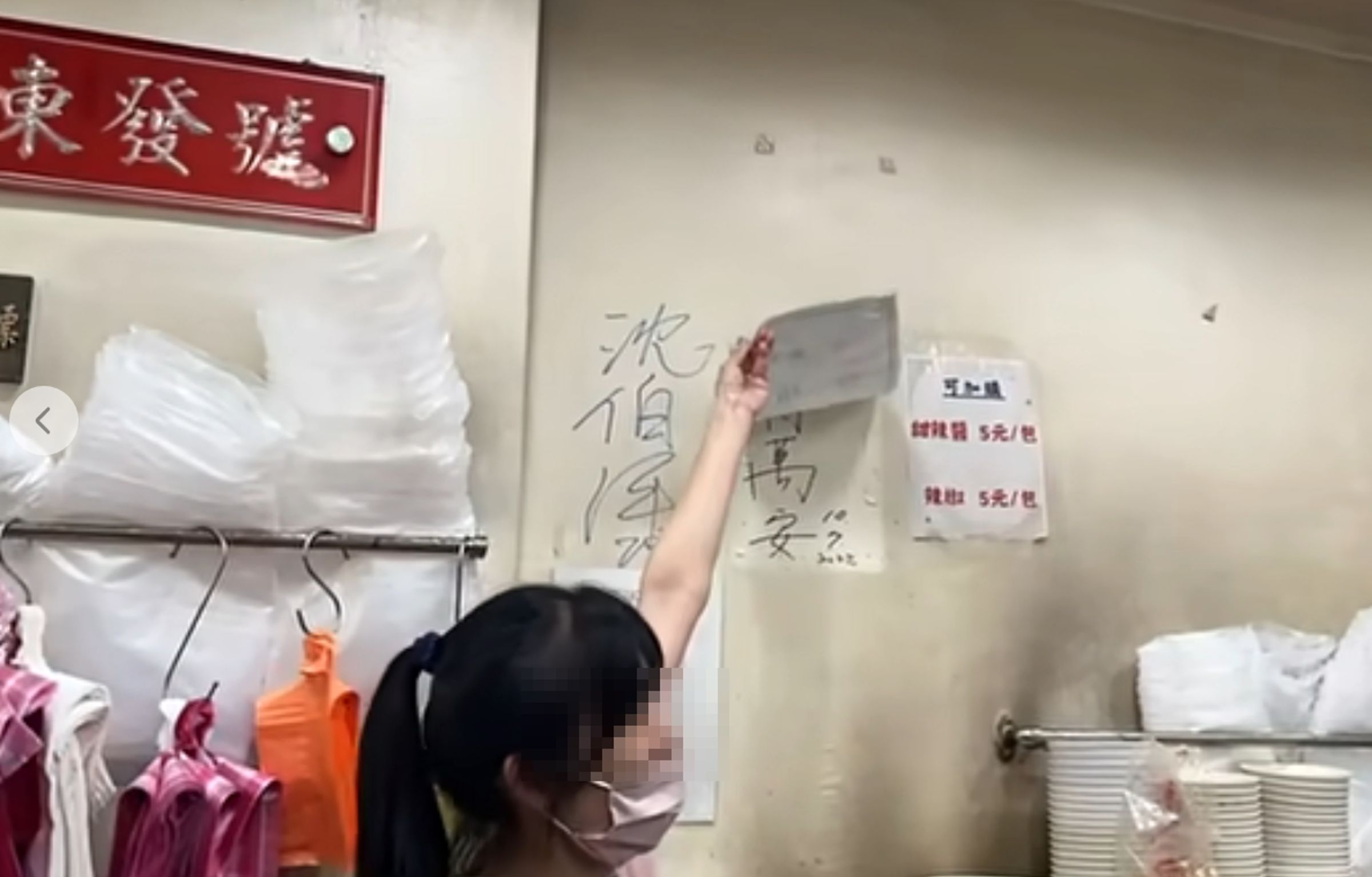 沈伯洋光顧百年老店「東發號麵線」時,店家邀請他幫忙簽名,並掀開「蓋住」許久的蔣萬安簽名。(翻攝自周軒臉書)