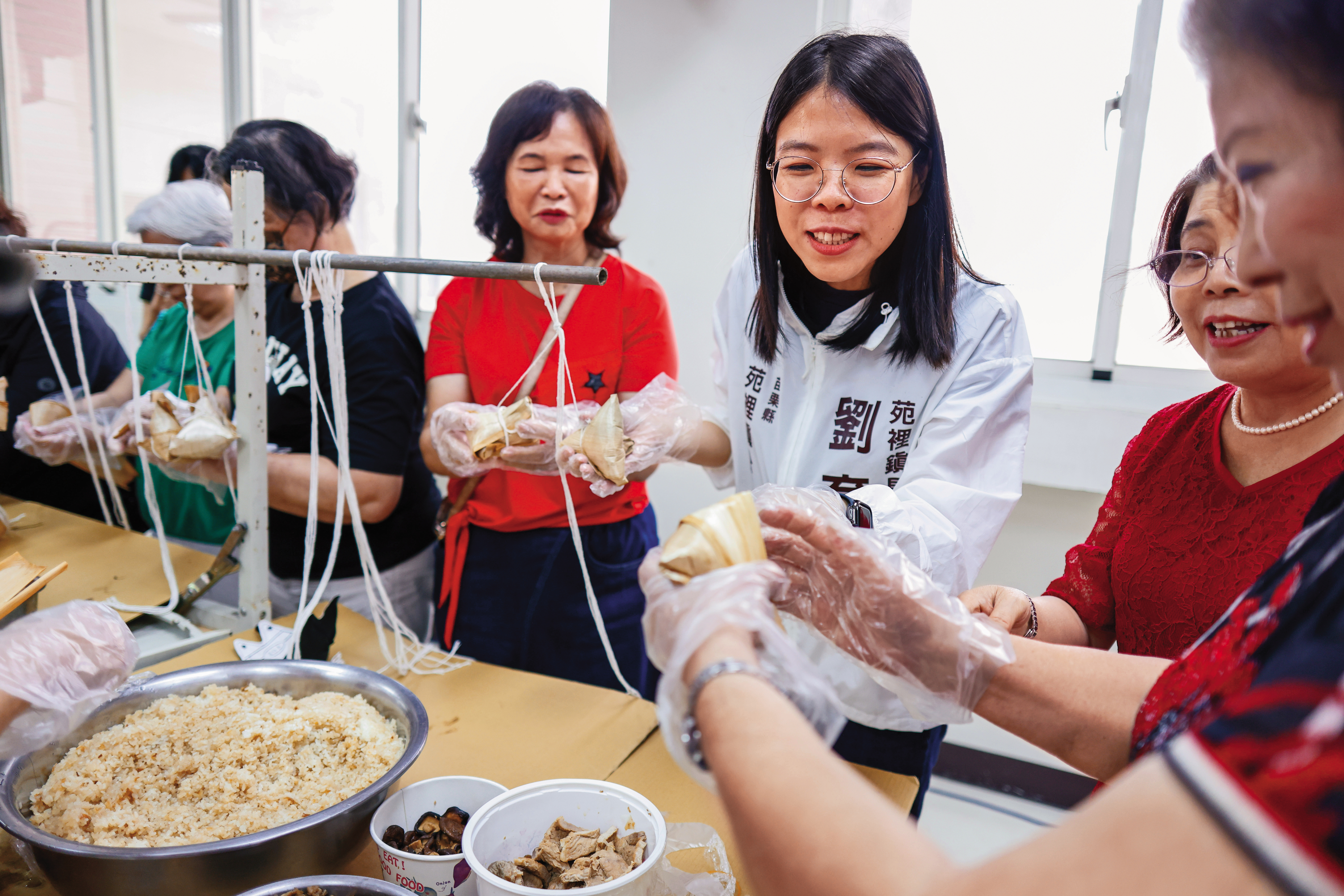 劉育育（中）與婆婆媽媽們一起包端午節粽子。