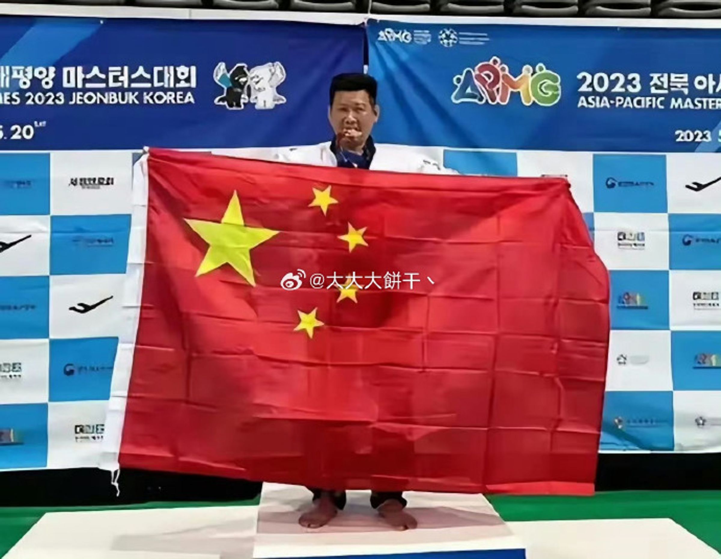 李東憲參加南韓「亞太壯年運動會」時,在頒獎台上高舉五星旗。(翻攝自微博)