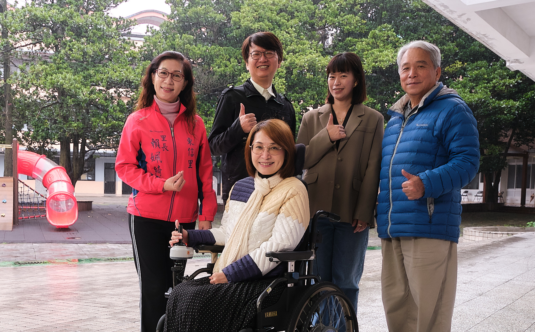 基隆市社會處處長楊玉欣（前）。後排左起：東信里長賴姵綺；東信國小校長曾恕華；家長會長潘亮岑；信綠里長吳銘達，共同打造以社區為單位、以家庭為中心的日間照顧服務模式。