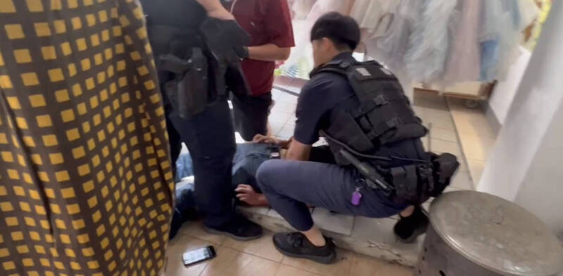 眾人先壓制搶劫銀樓金項鍊的少年，警方隨即趕到，接手將少年回派出所偵辦。（讀者提供）