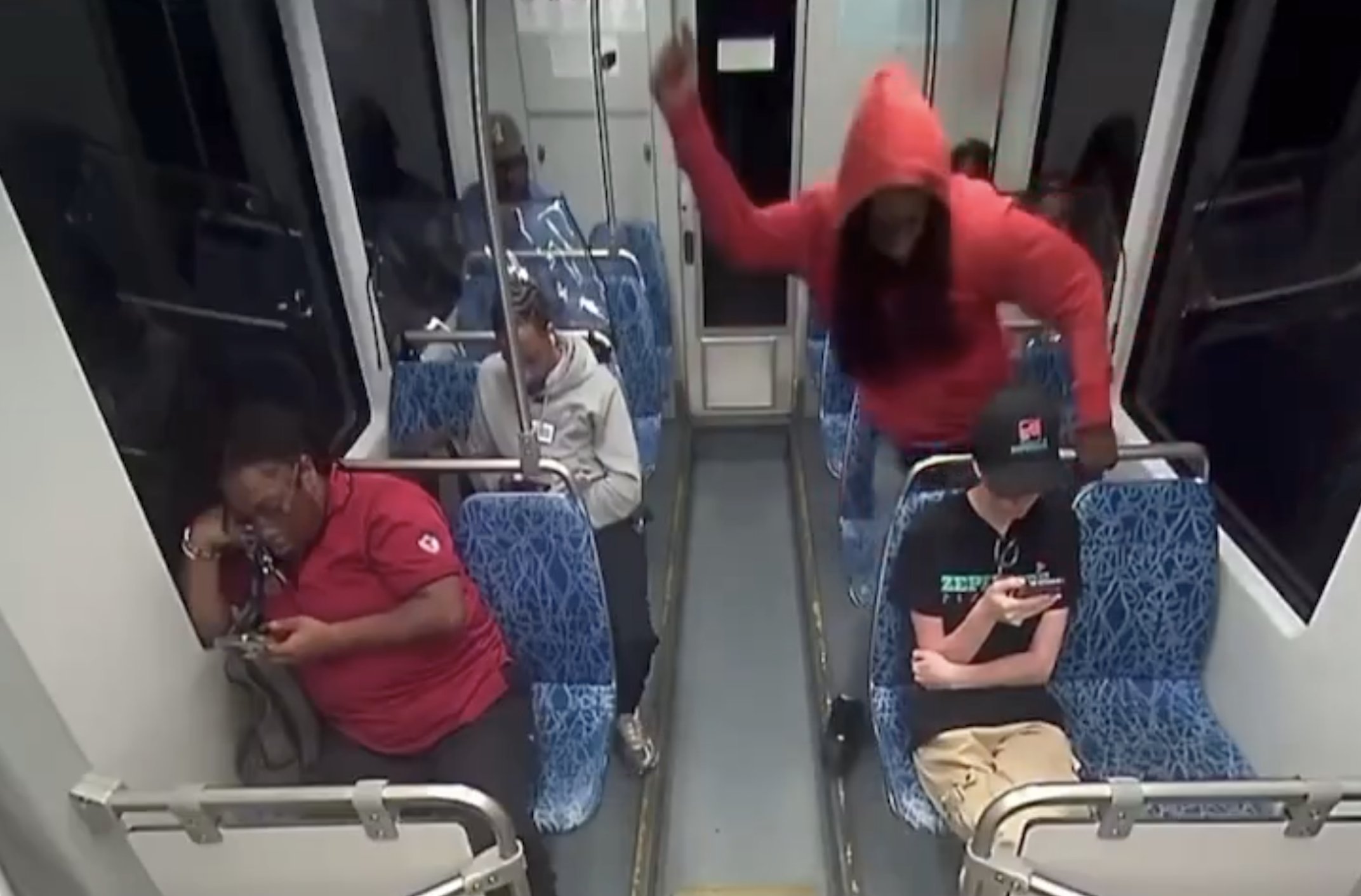 伊琳娜（右前戴黑帽者）在電車上遭布朗（右排後紅衣者）隨機殺害，案發畫面曝光，震驚全美。（翻攝畫面）