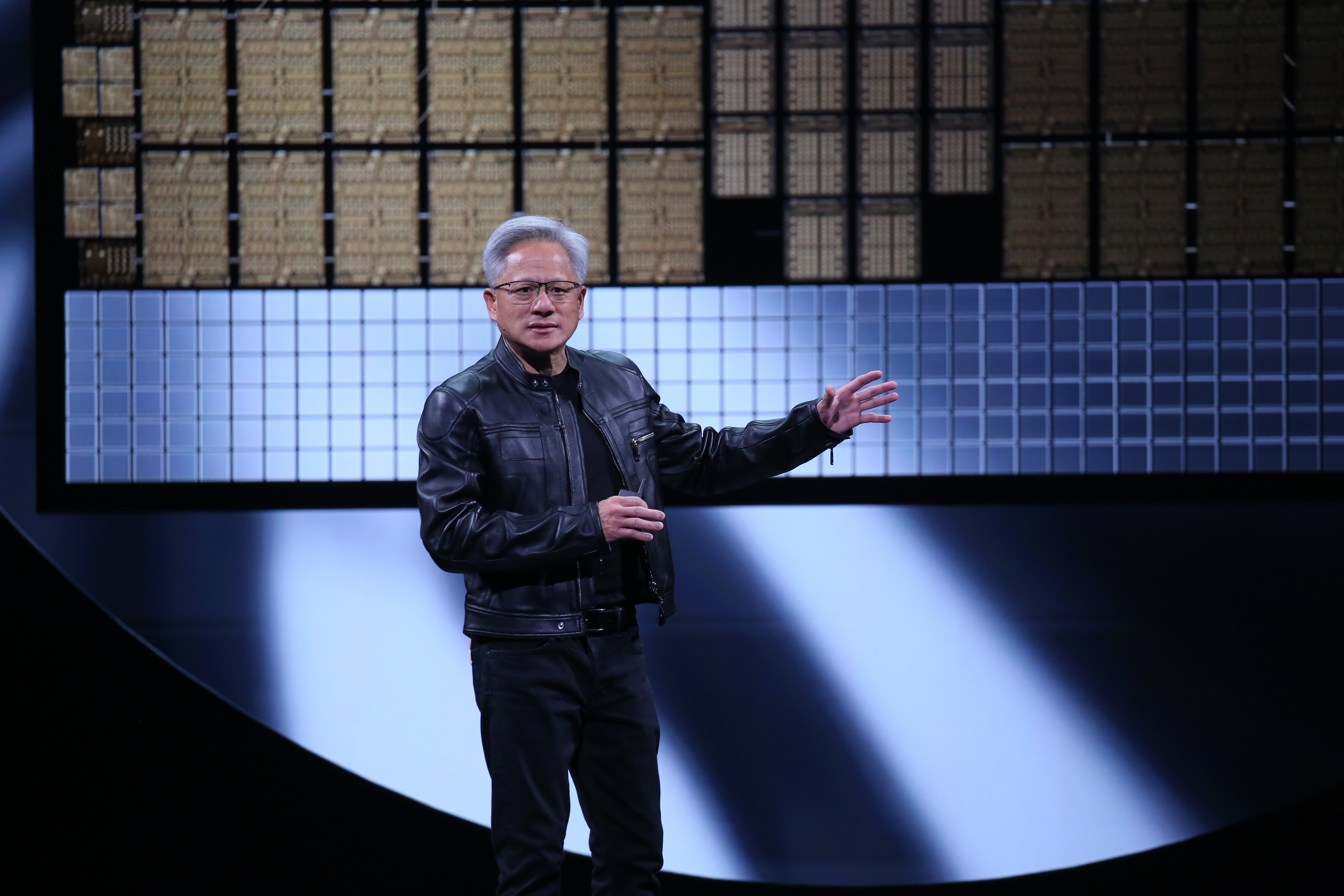 輝達創辦人黃仁勳穿上招牌皮衣進行演講，吸引台灣科技業大老闆們台下排排坐，以行動支持他的AI發展藍圖。（鏡報新聞網提供）